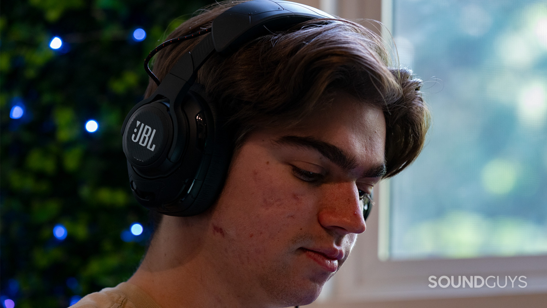 A person wearing the JBL Quantum One headset and facing downwards