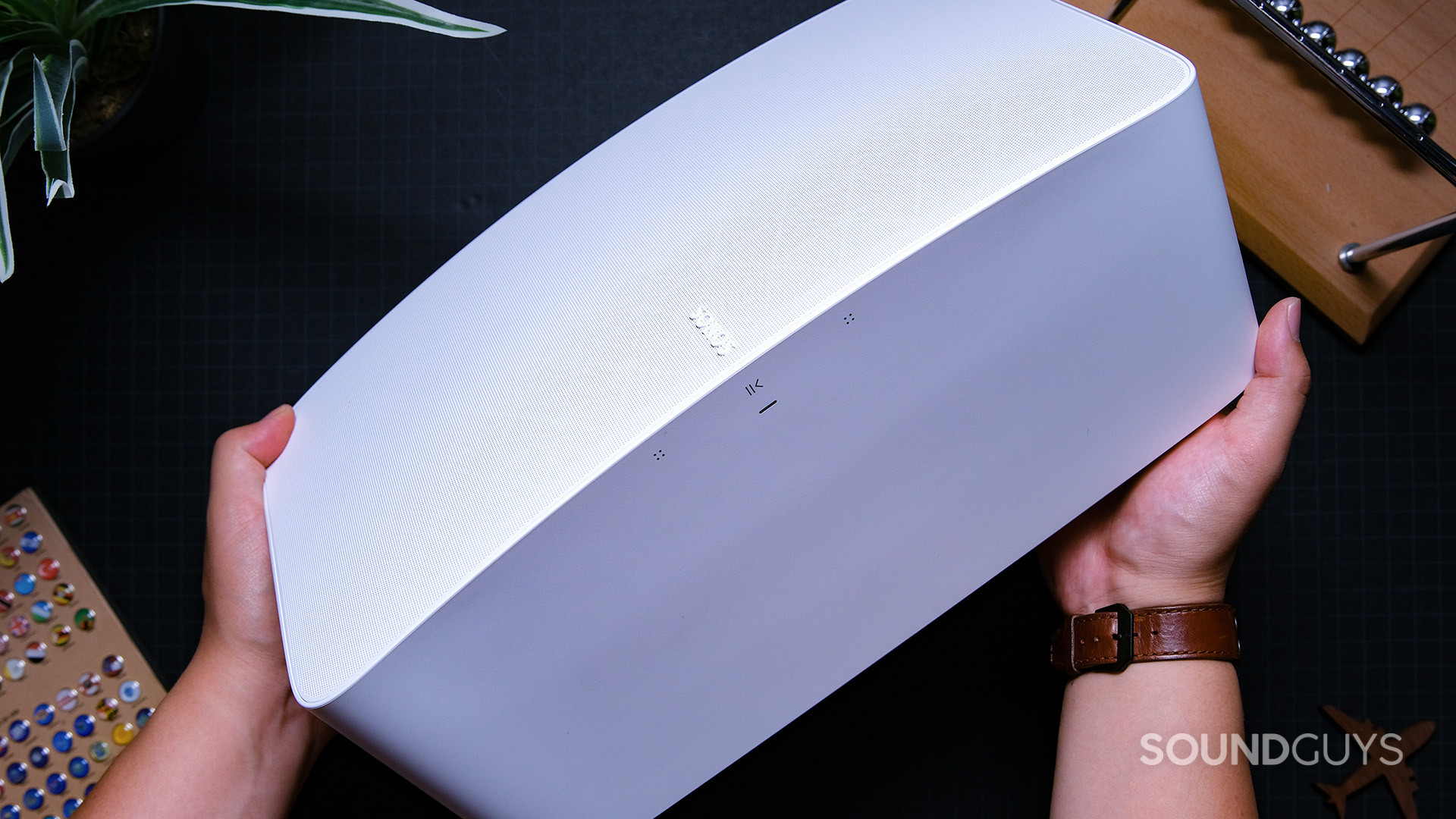 A white Sonos Five speaker shown at an angle from the top down against a dark background.