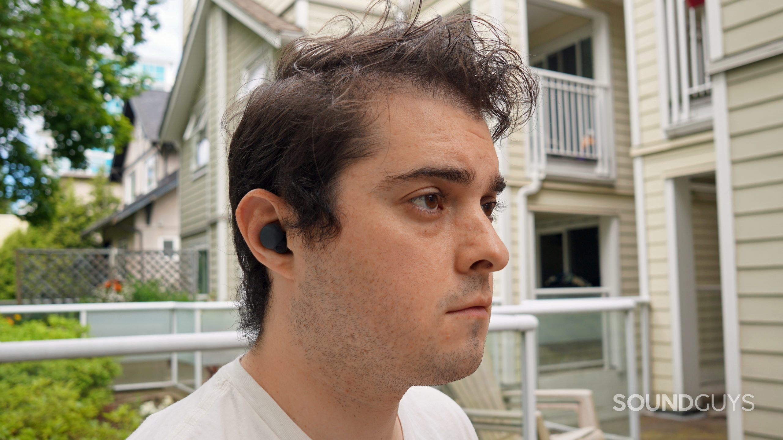 A man sits outside wearing the Sony LinkBuds S