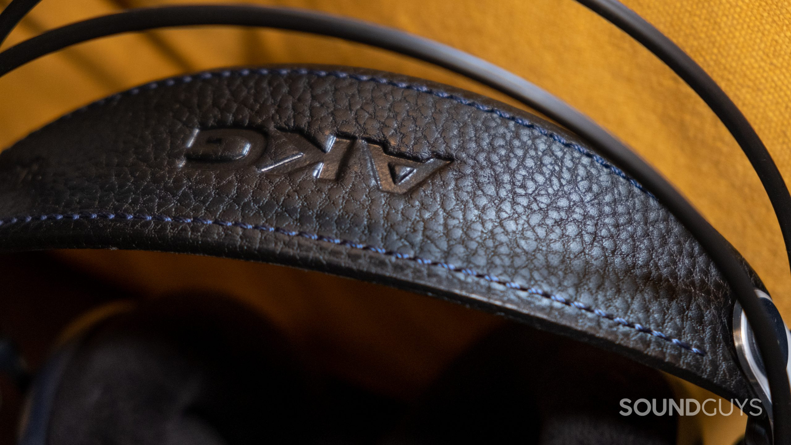 A close up of the AKG K702 leather headband with yellow fabric in the background.