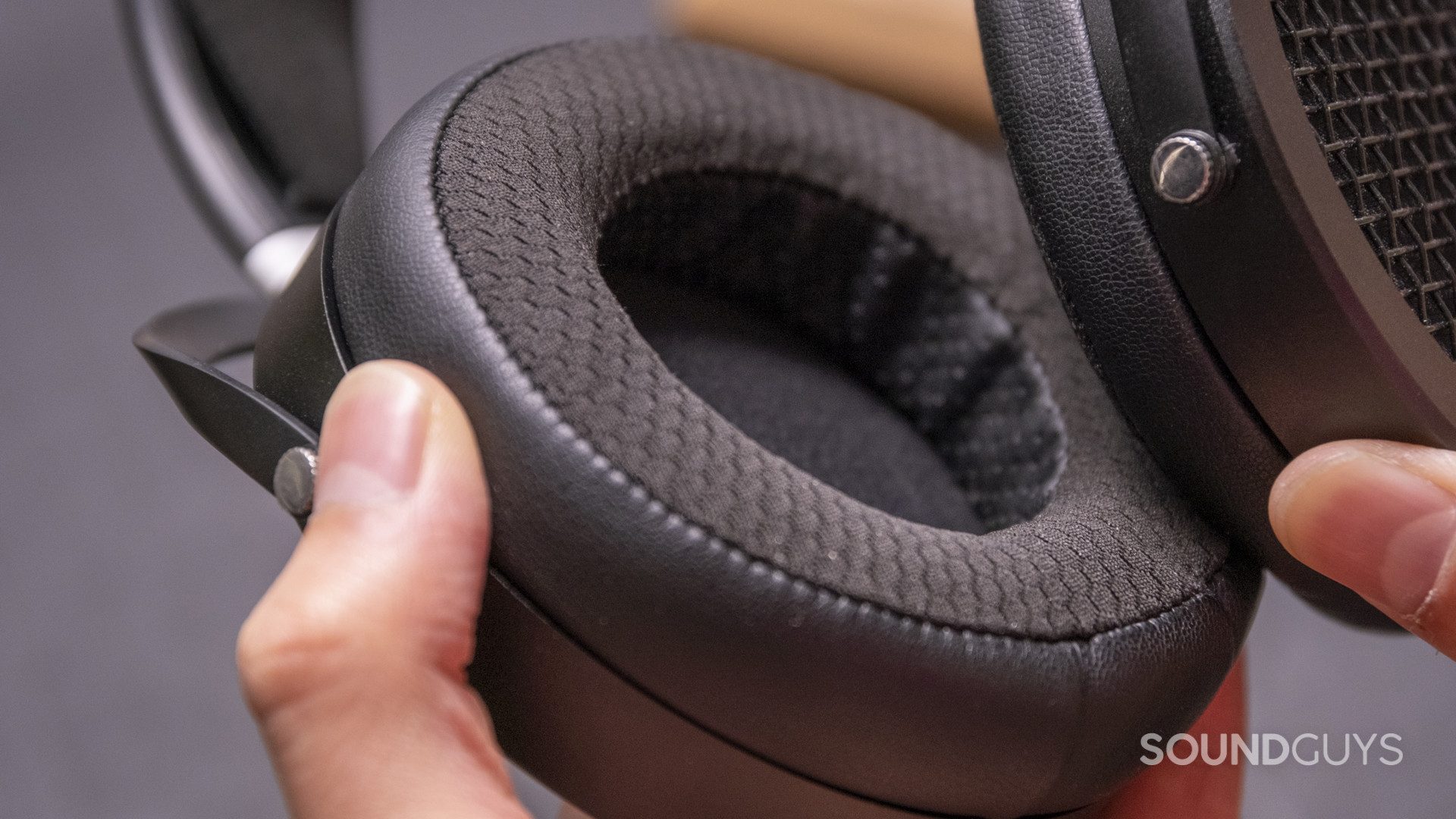 A hand holds the HiFiMan Sundara mixed-material ear pads.