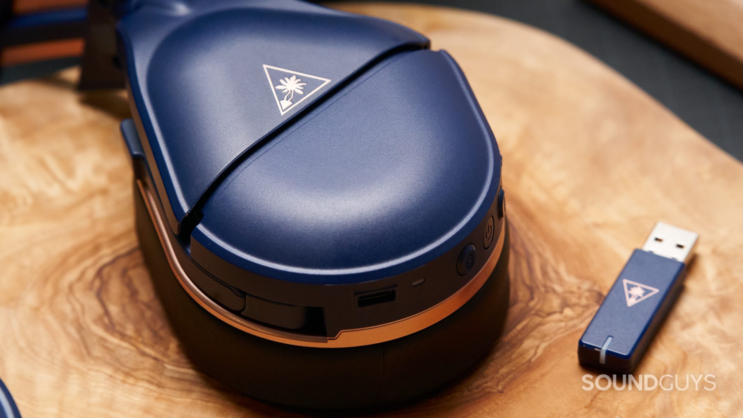 The Turtle Beach Stealth 700 Gen 2 MAX on a wooden tabletop next to its USB connector.