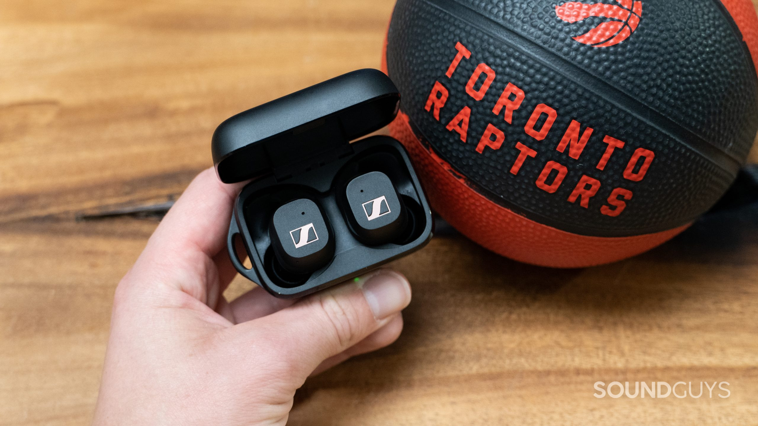 Sennheiser Sport True Wireless earbuds next to a basketball