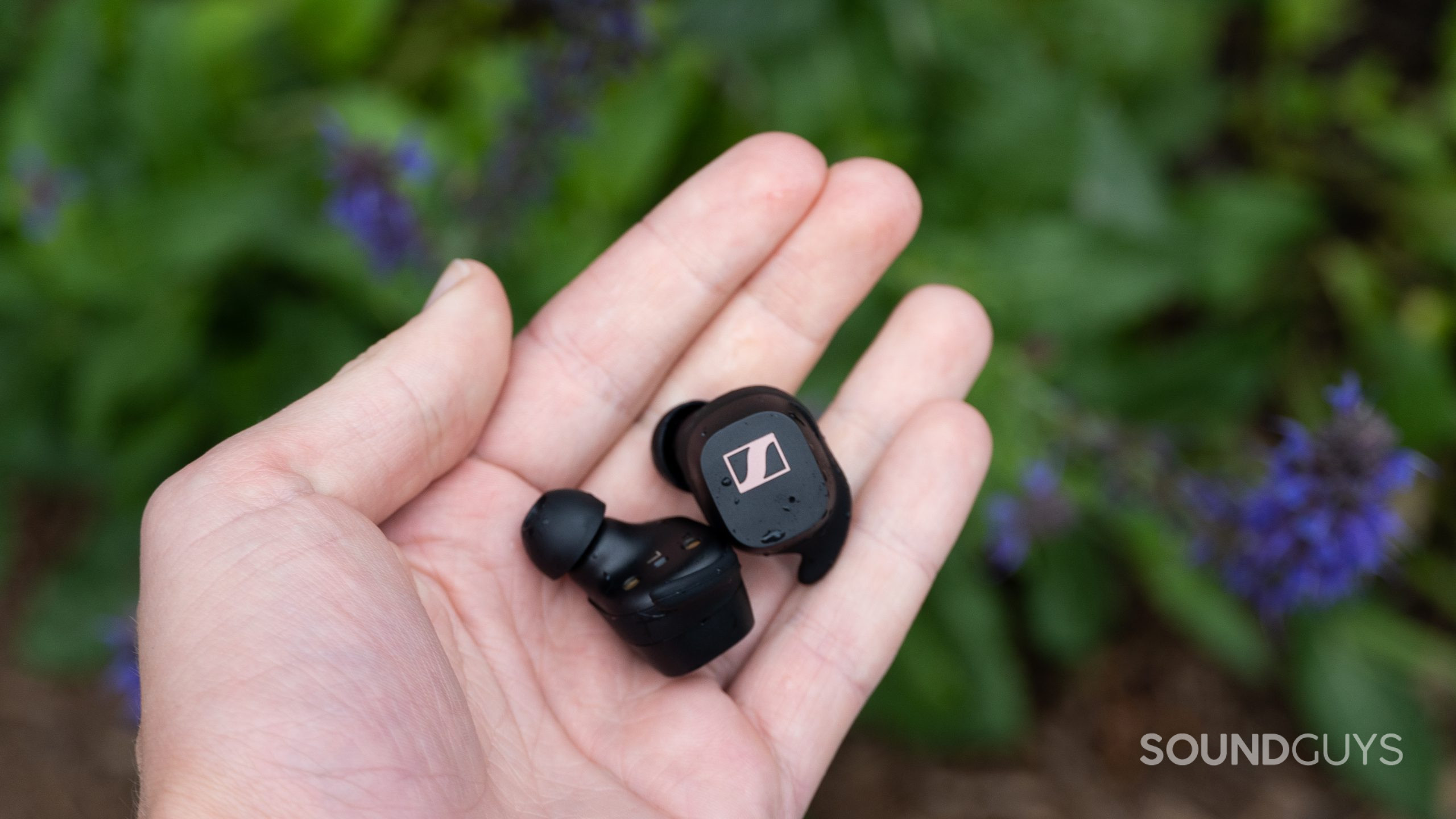 Sennheiser Sport True Wireless earbuds held in a hand