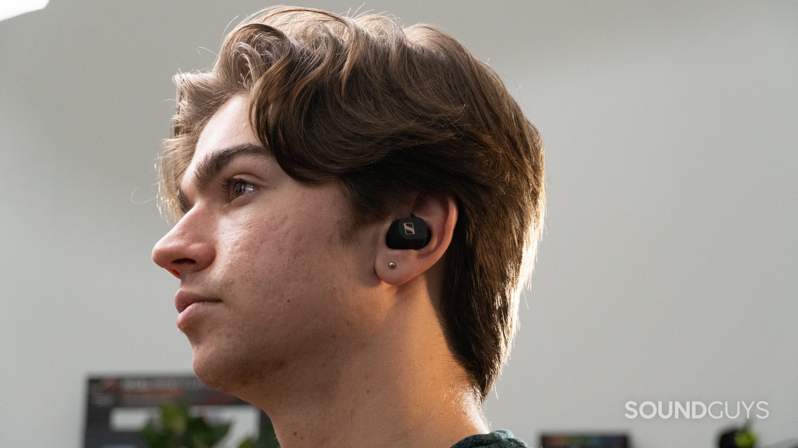 Sennheiser Sport True Wireless earbuds inside a mans ear as he looks to the left