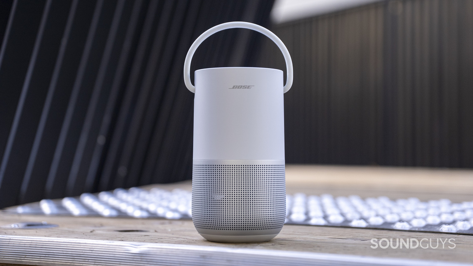 A Bose Portable Smart Speaker sitting outside on a wooden deck.