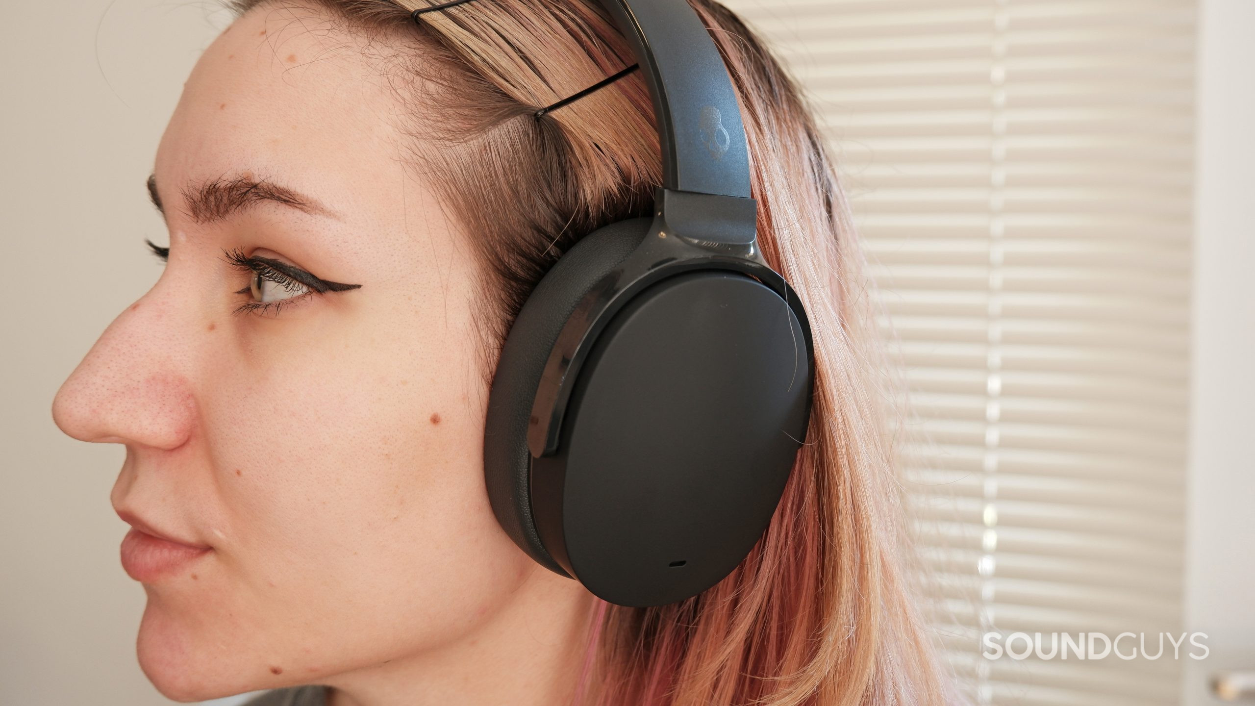 A woman wearing the Skullcandy Hesh ANC, looking to the side.