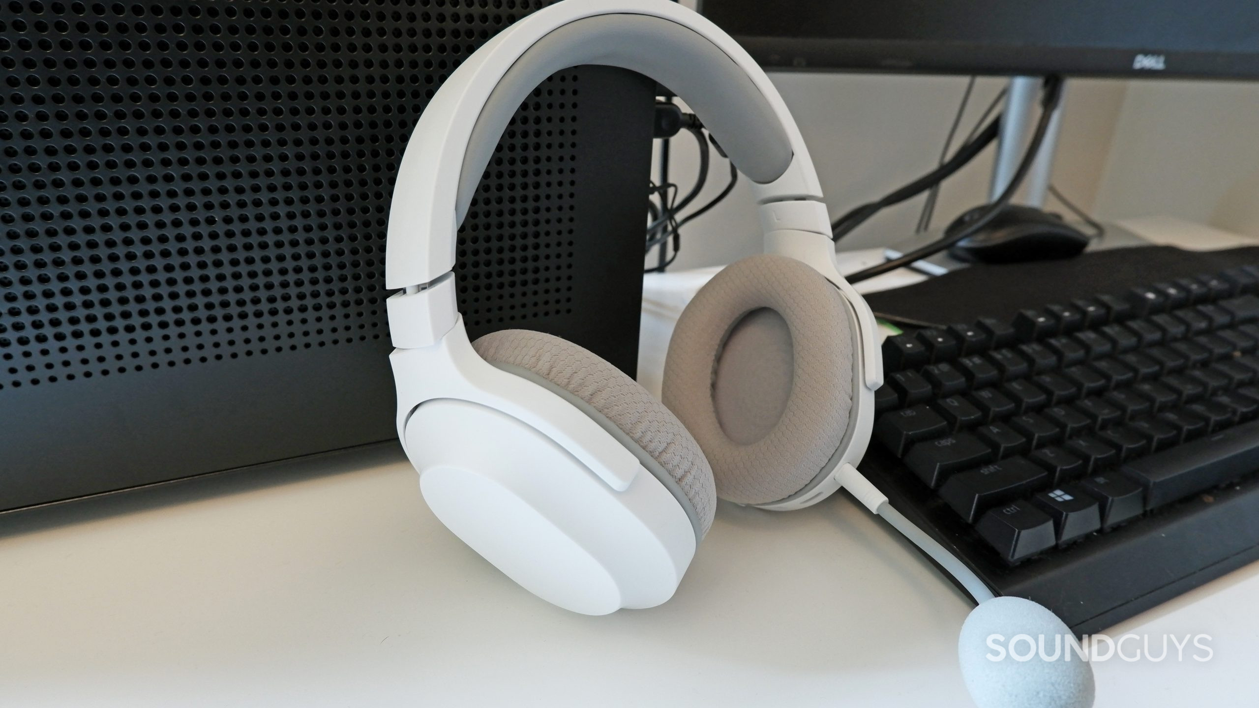 The Razer Barracuda X (2022) resting against a PC on a white desk.