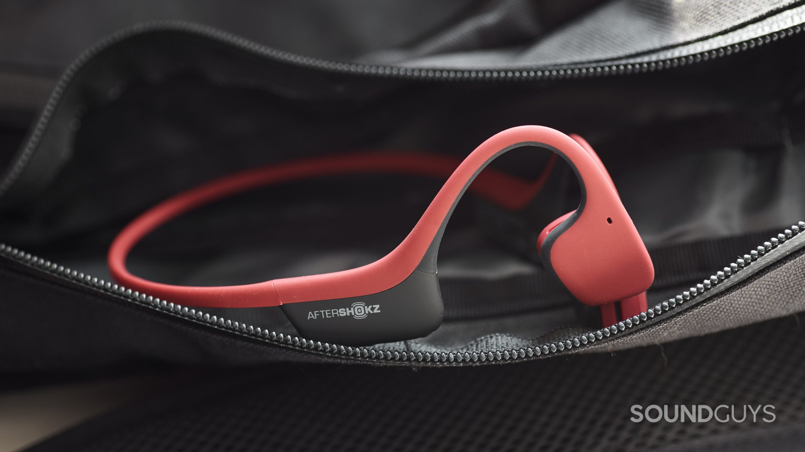 The AfterShokz Air bone conduction headphones in a zippered sling.