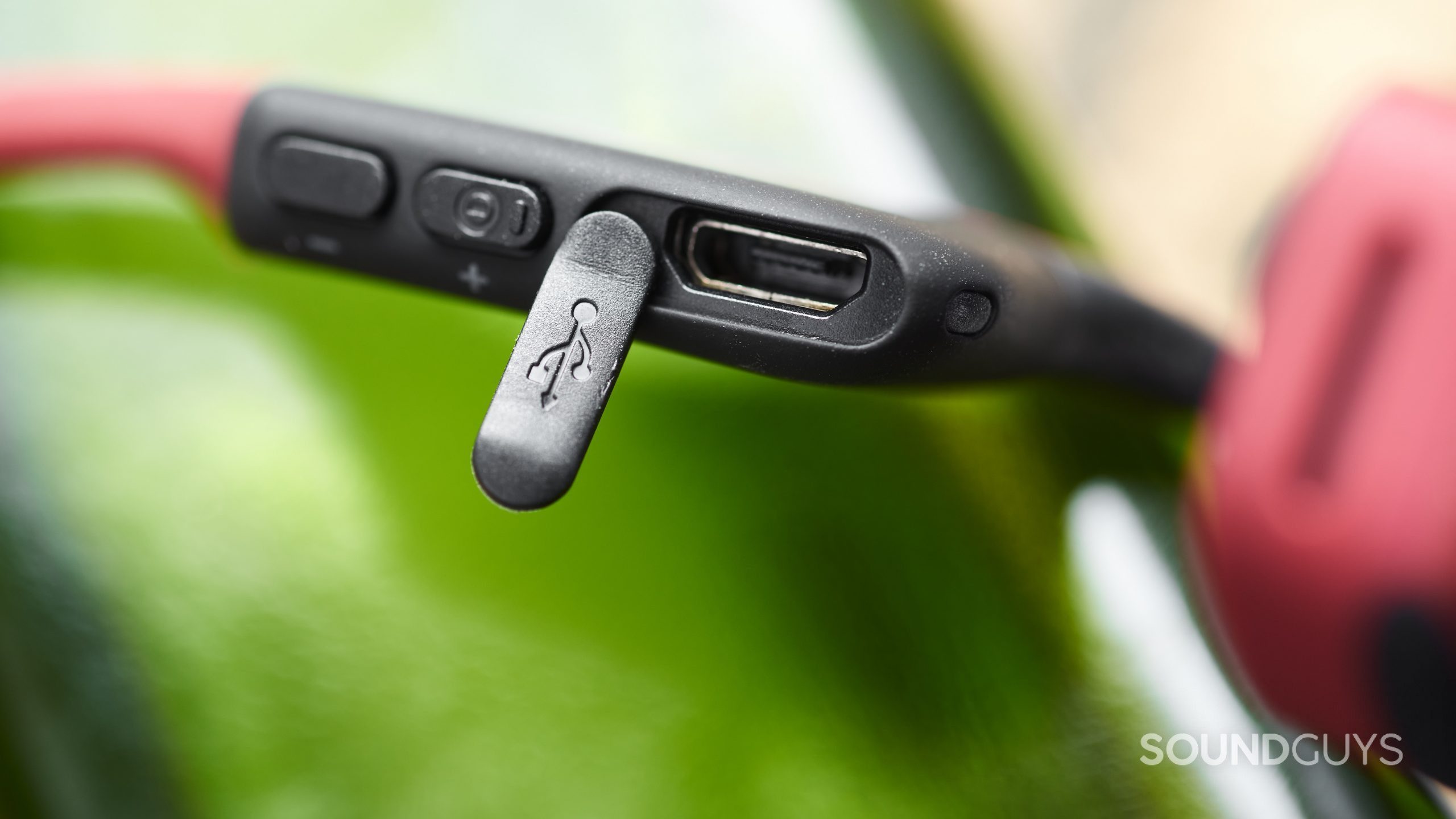 The AfterShokz Air bone conduction headphones' microUSB port revealed with the protective flap off to the side.