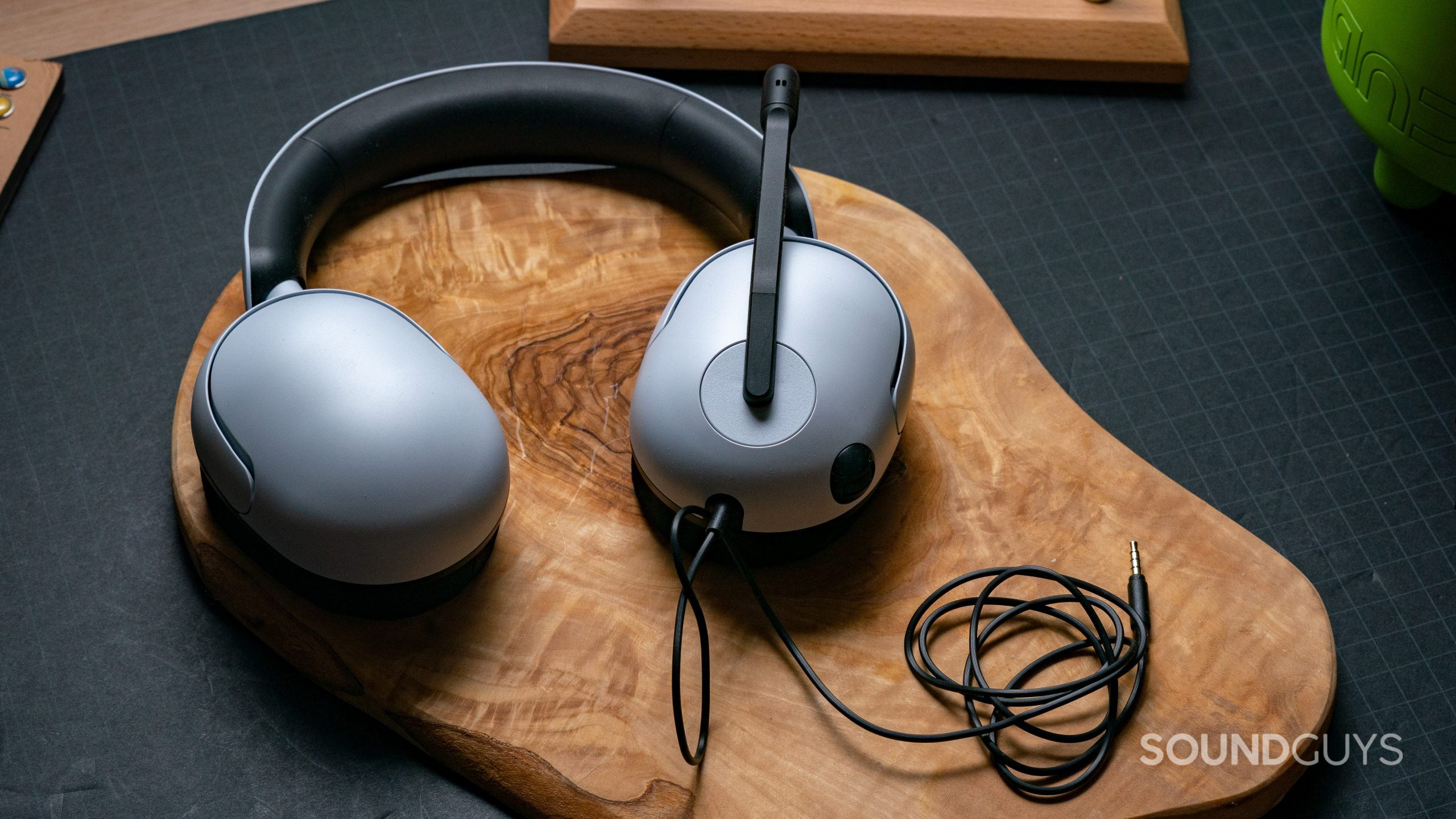 The Sony INZONE H3 sitting on a block of wood with the 3.5mm audio cable coiled up next to it.