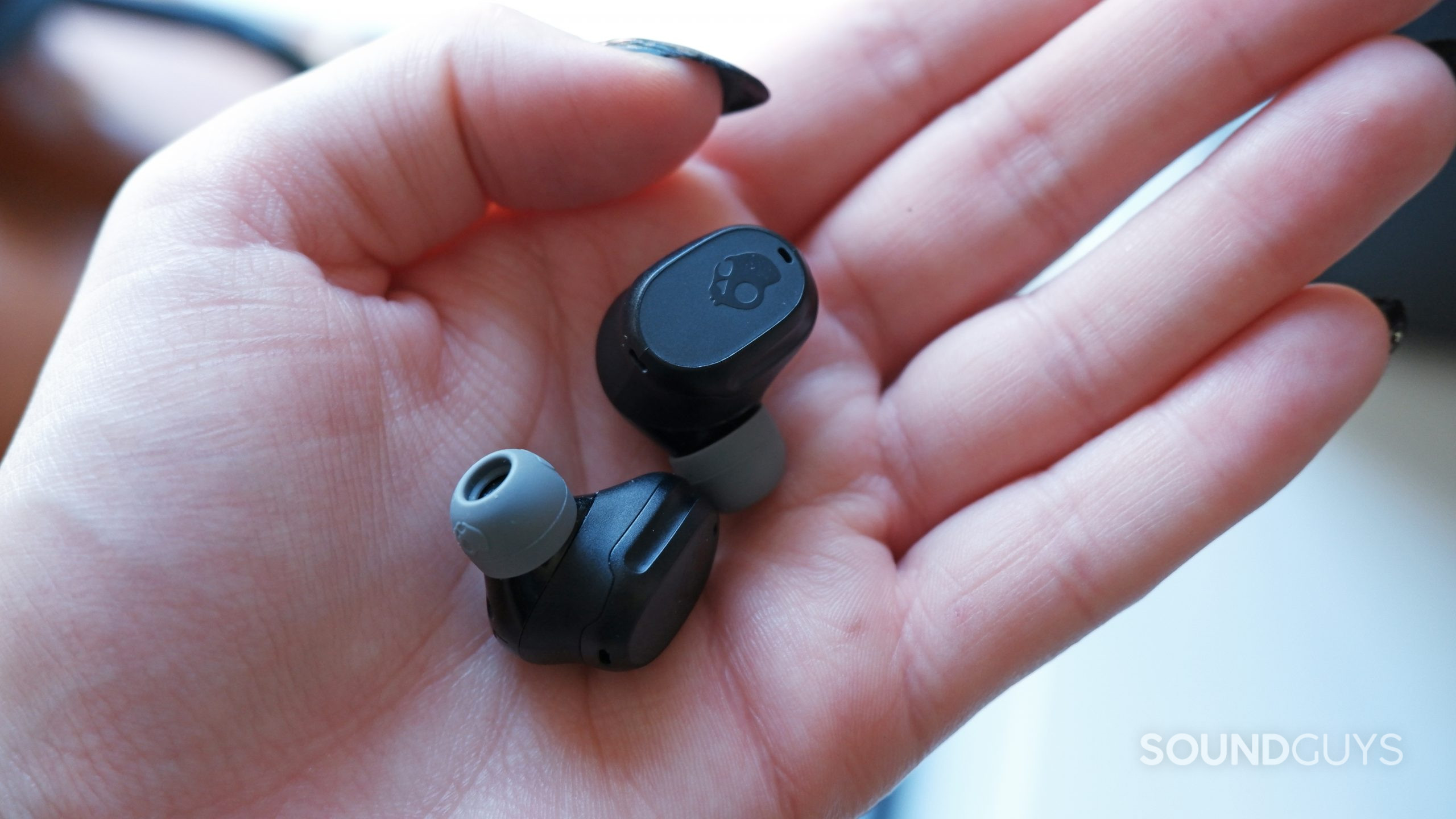 The Skullcandy Mod XT earbuds in a hand.