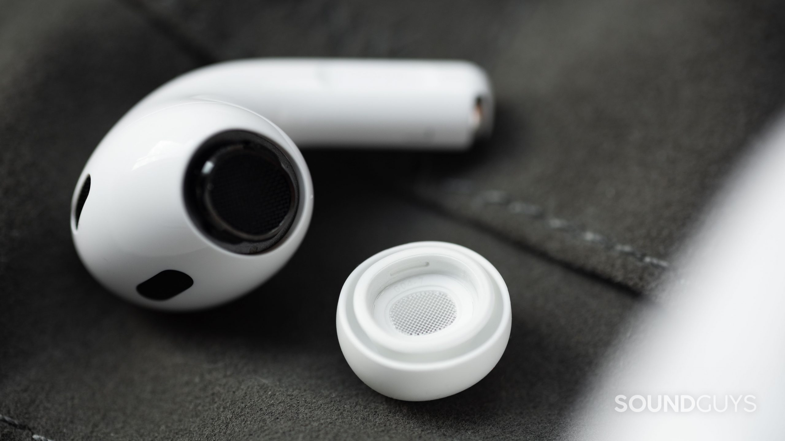 The Apple AirPods Pro (2nd generation) ear tip separated from the housing with the wax guard in focus.