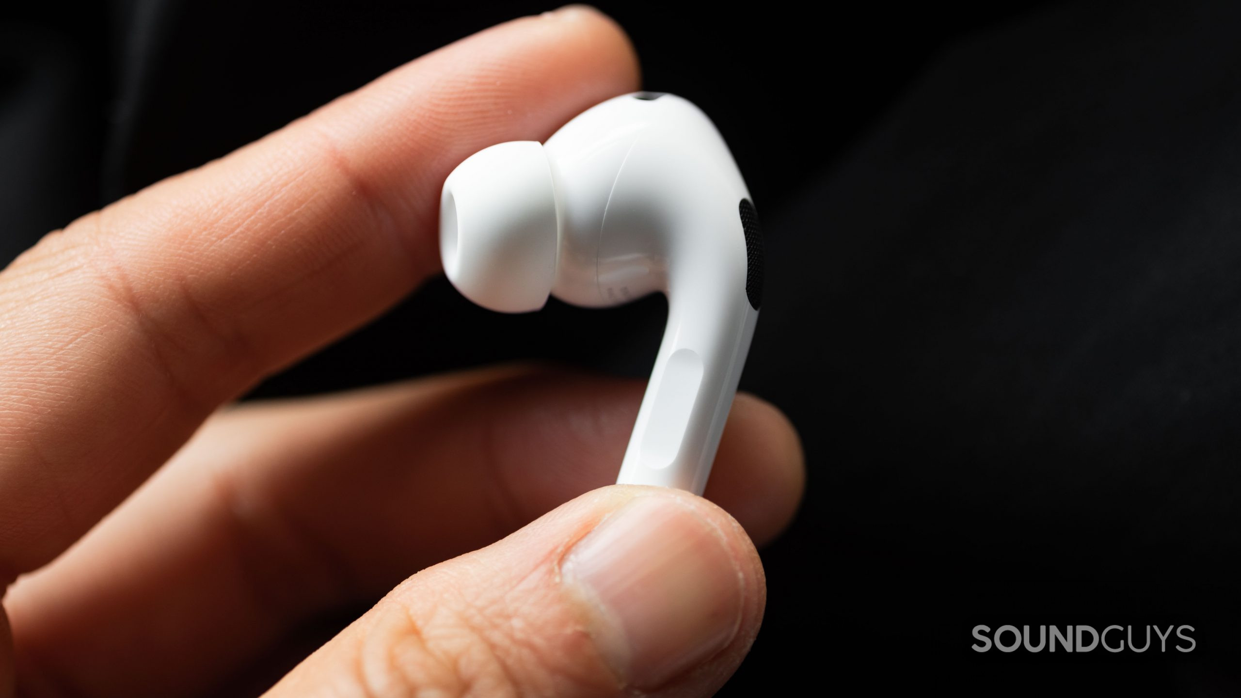 A hand holds the left earbud of the Apple AirPods Pro (2nd generation) to show off the stem.