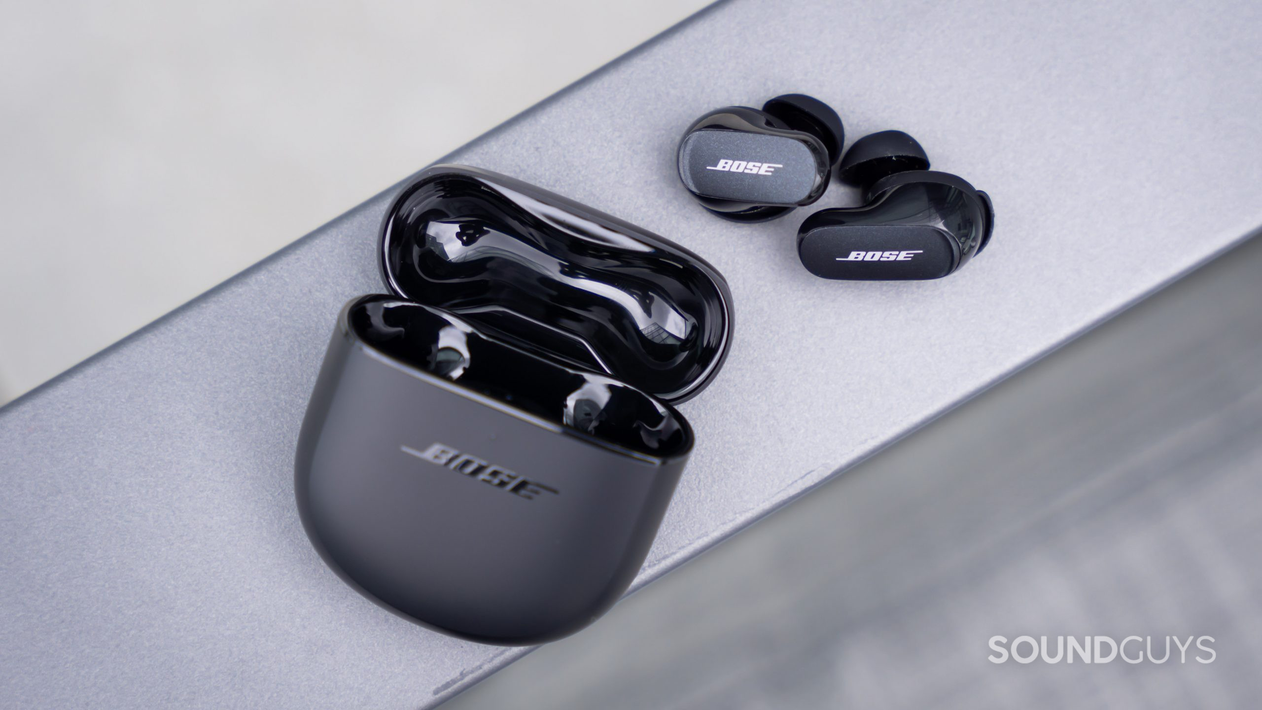 An aerial view of the Bose QuietComfort Earbuds II with the open case and earbuds, as if the buds are spilling out.