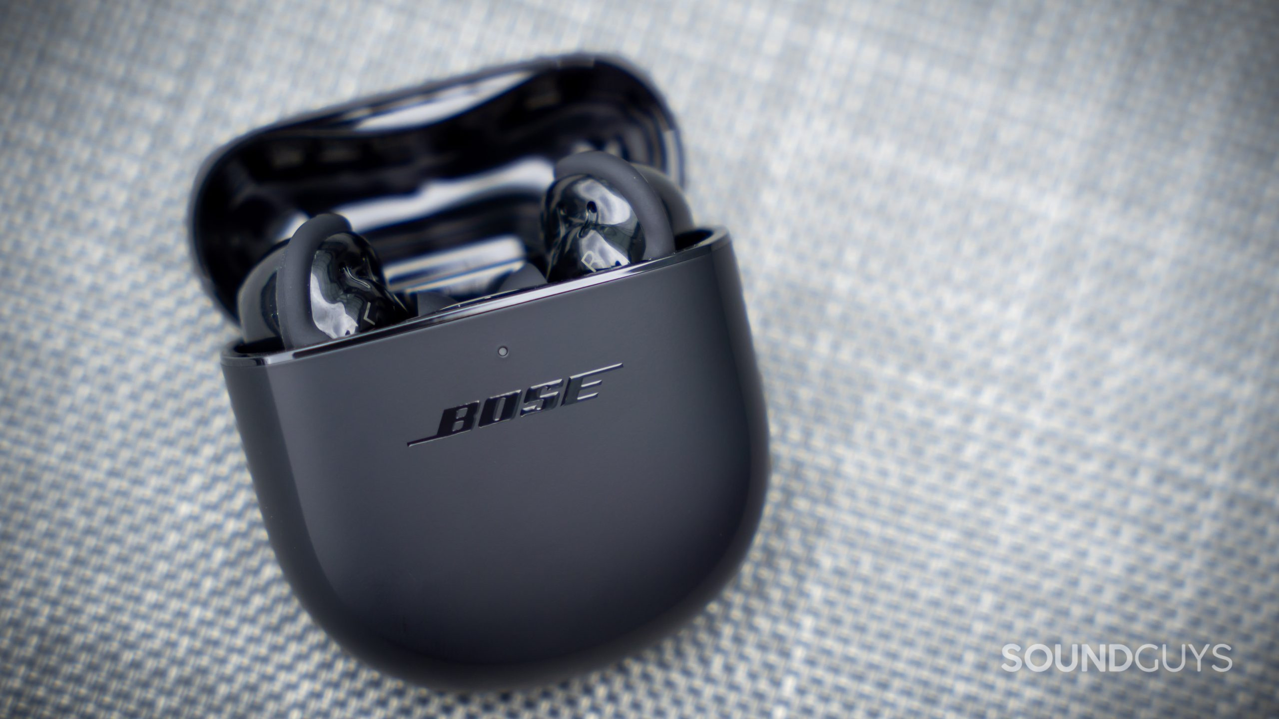 The open Bose QuietComfort Earbuds II charging case with the earbuds inside.