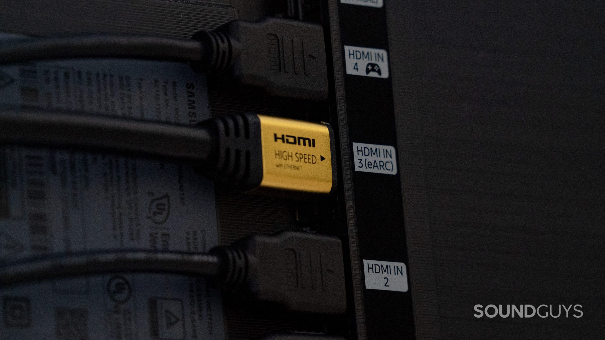 A row of HDMI input sockets on the back of a TV, one of which is labelled HDMI eARC. A cable is plugged into each one.