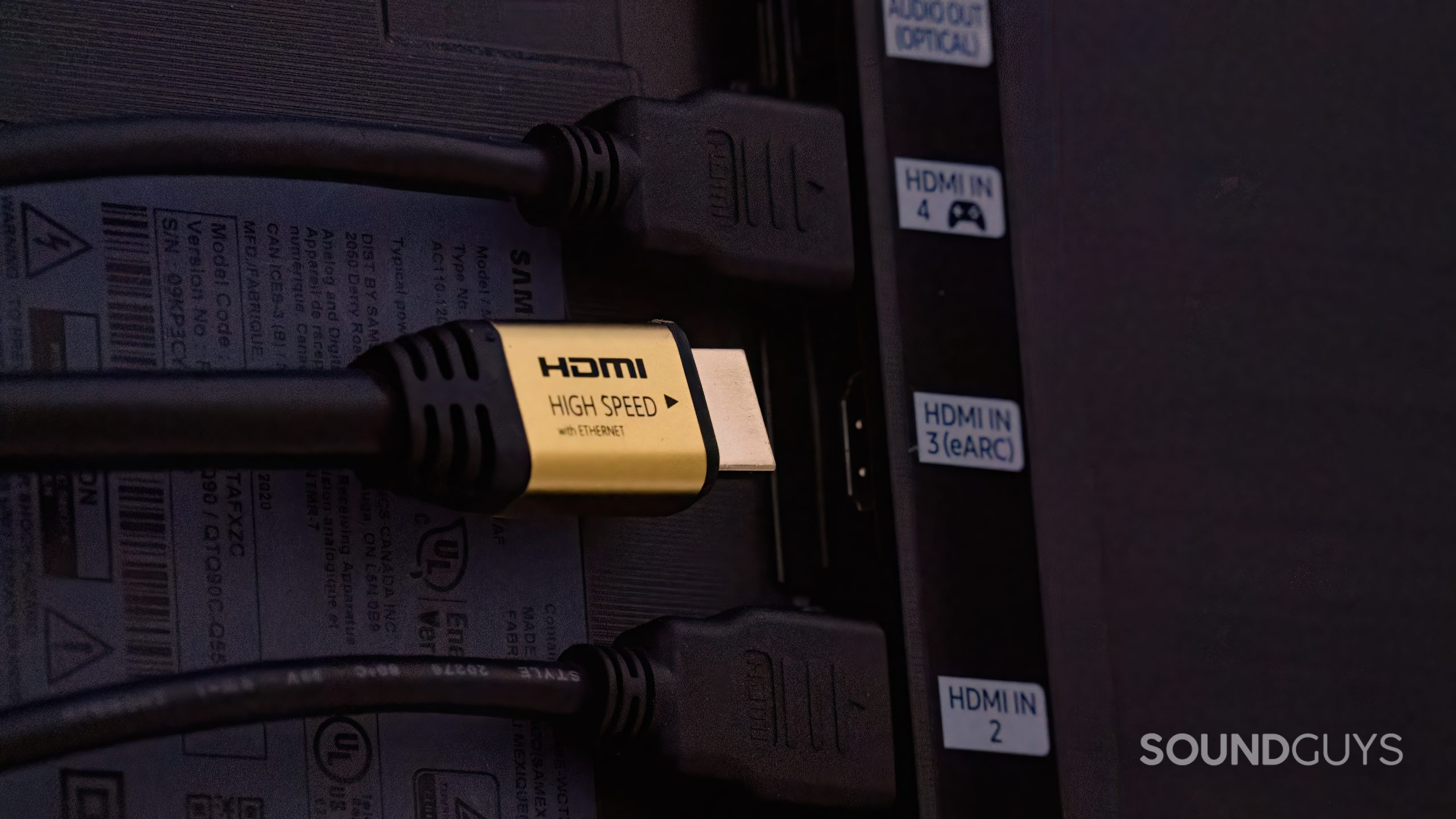 A row of HDMI input sockets on the back of a TV, one of which is labelled HDMI eARC. A cable is being plugged into this one.