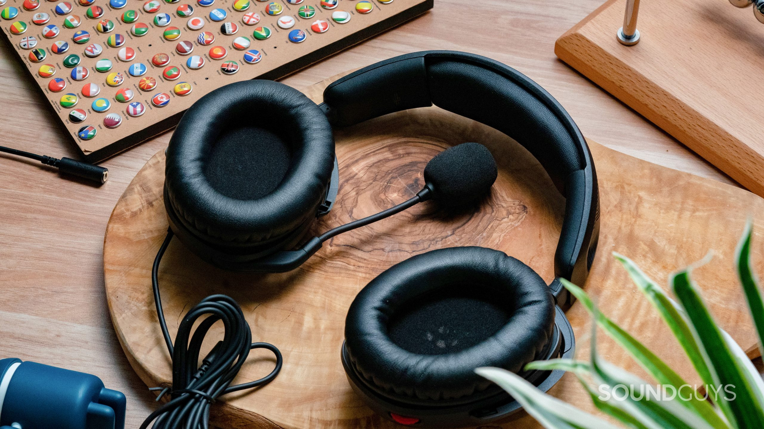 The HyperX Cloud Stinger 2 sitting on a wooden tabletop with the microphone laid flat in the middle.