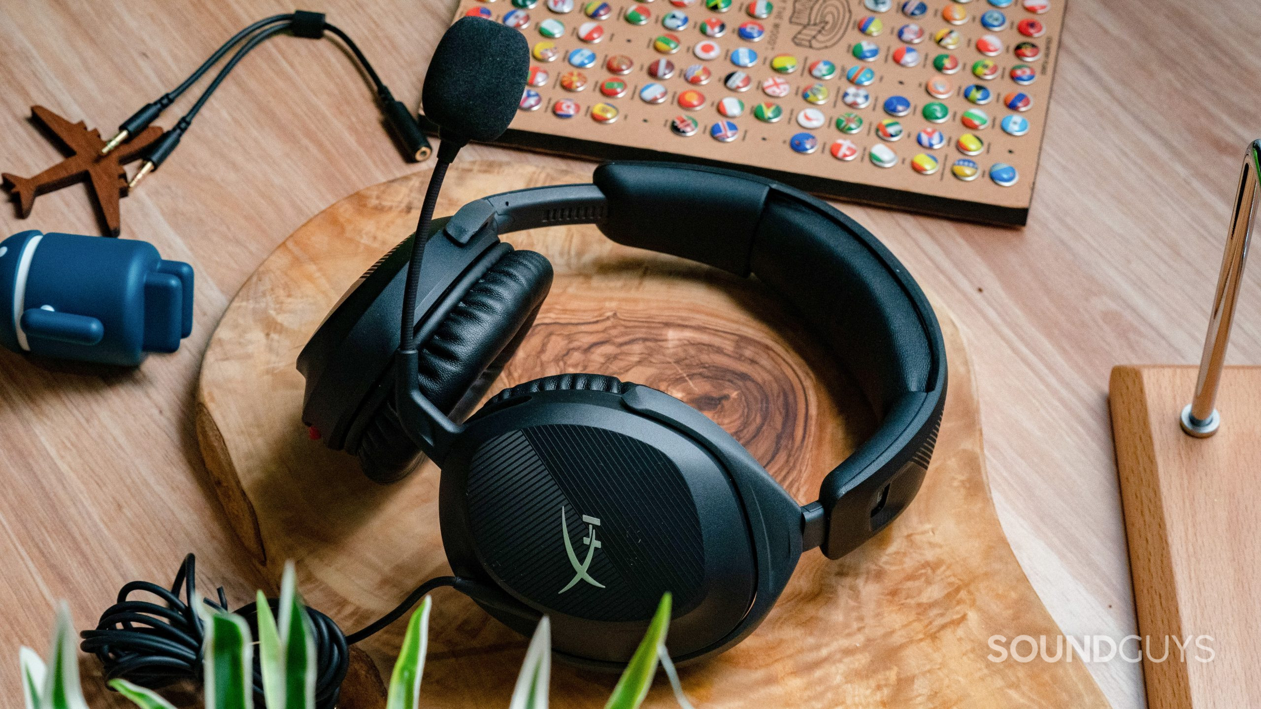 The HyperX Cloud Stinger 2 sitting on a wooden tabletop with the microphone in prominent view.