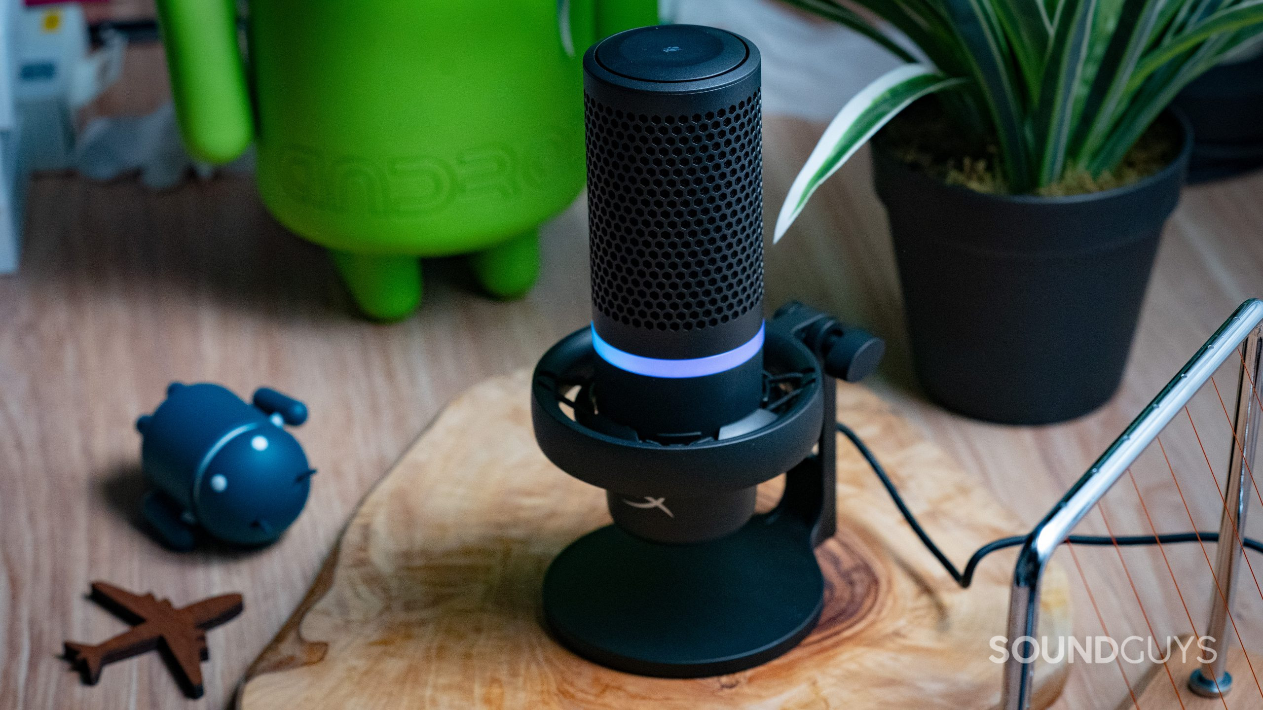 The HyperX DuoCast sitting on a wooden table with trinkets strewn around it.