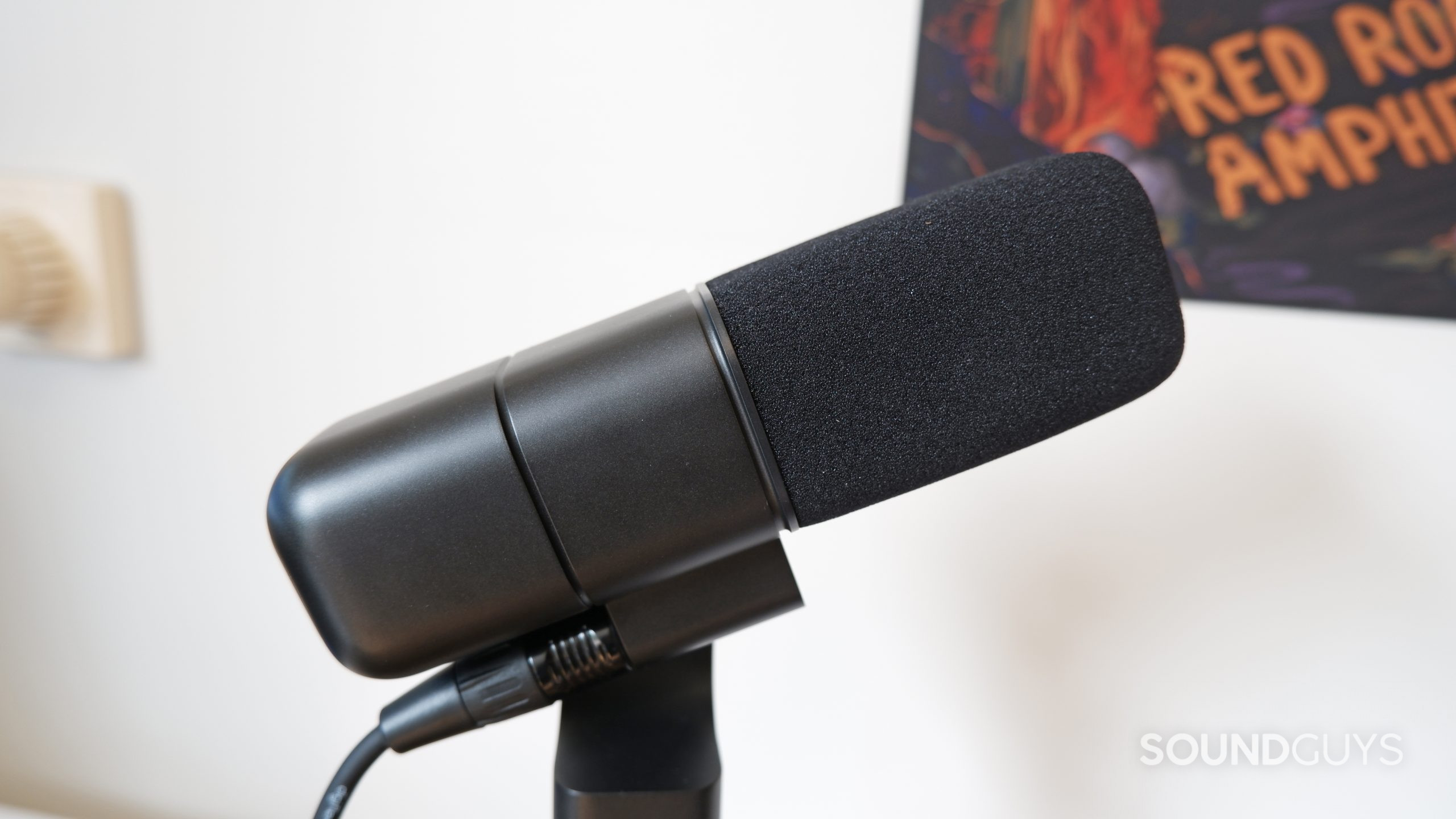 The Logitech Blue Sona XLR microphone mounted on a tripod in front of a white wall.