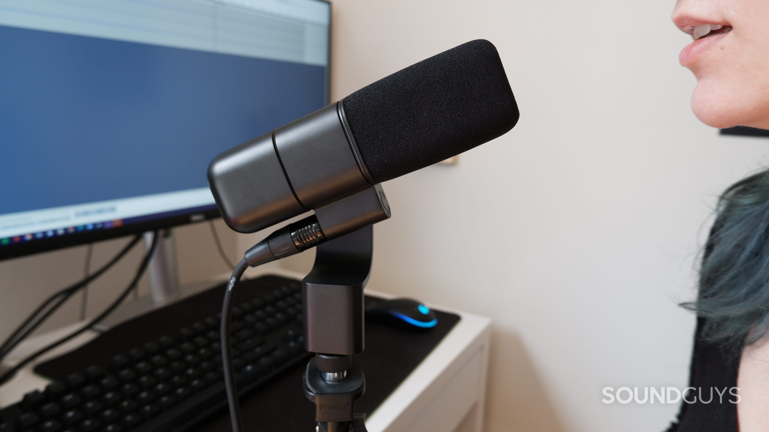 A person speaking into the Logitech Blue Sona at a desk with a digital audio workstation open.