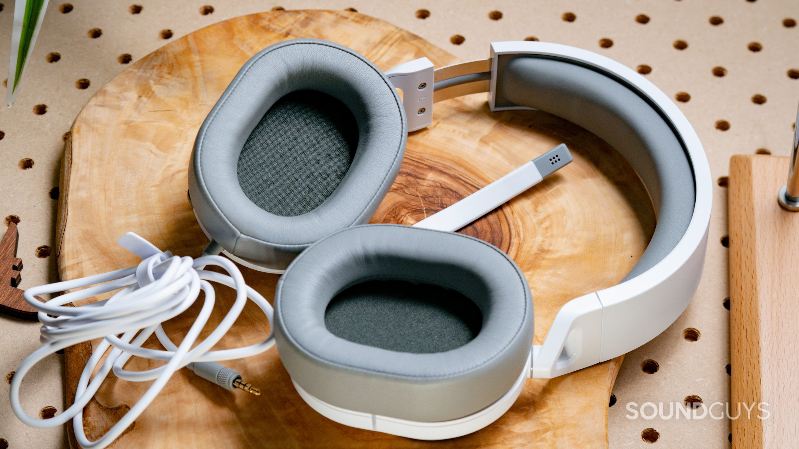 The Corsair HS55 Surround sitting on a wooden block with the ear cups facing towards the viewer.