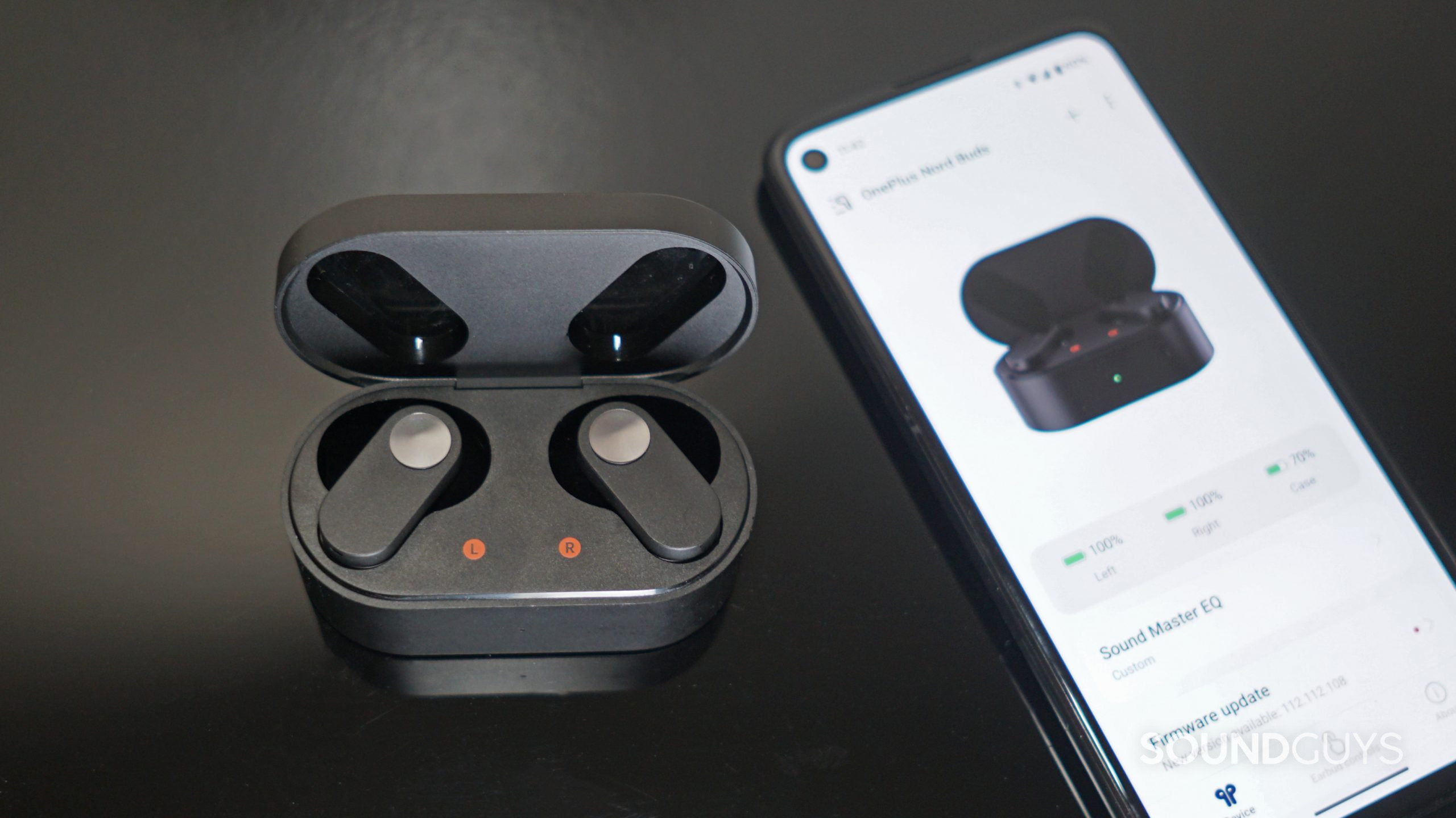 OnePlus-Nord-Buds-app The OnePlus Nord Buds sit in the charging case next to a google pixel 4a running the HeyMelody app.