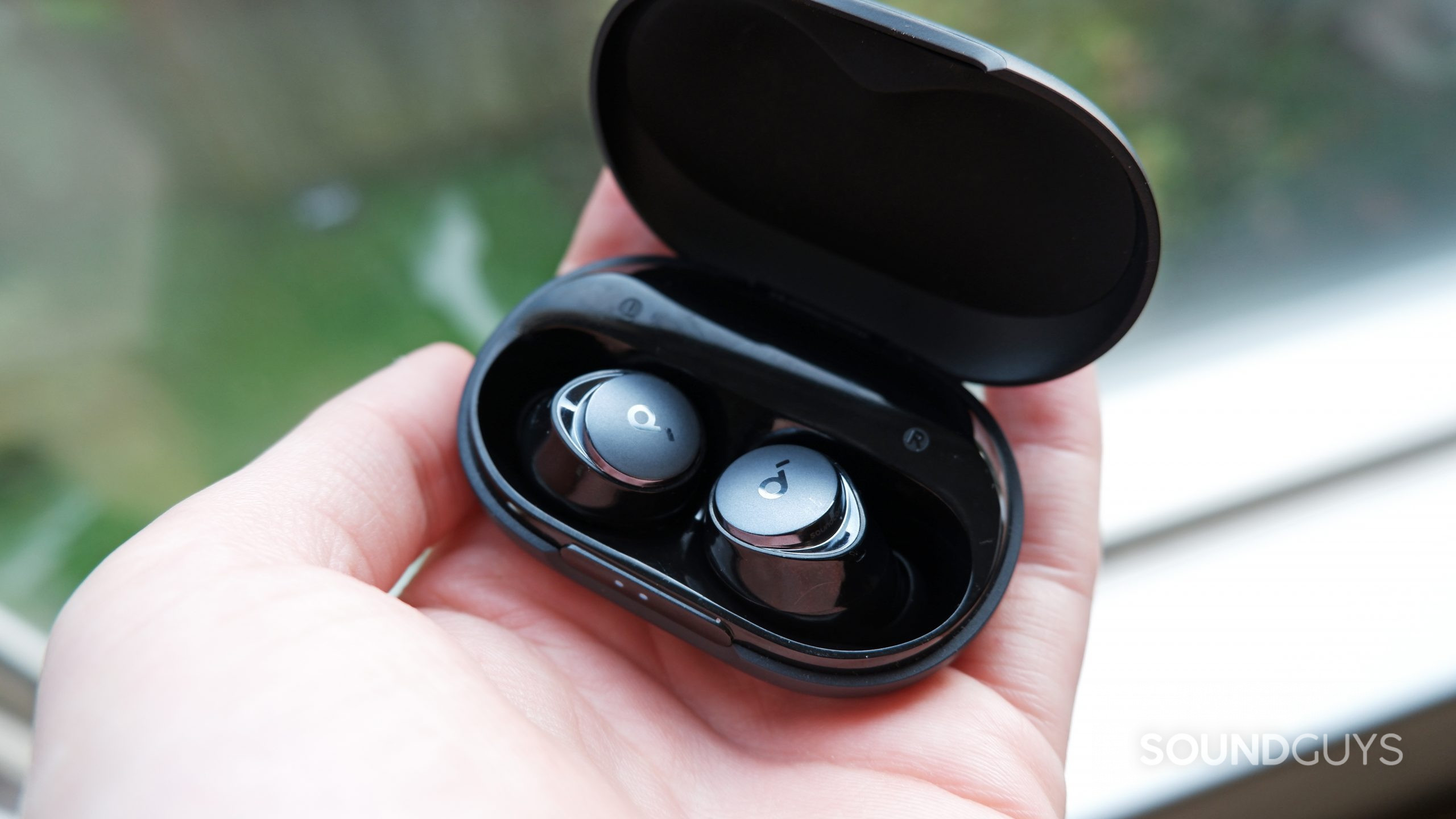 The Anker Soundcore Space A40's case open with the earbuds inside, resting on a person's hand.