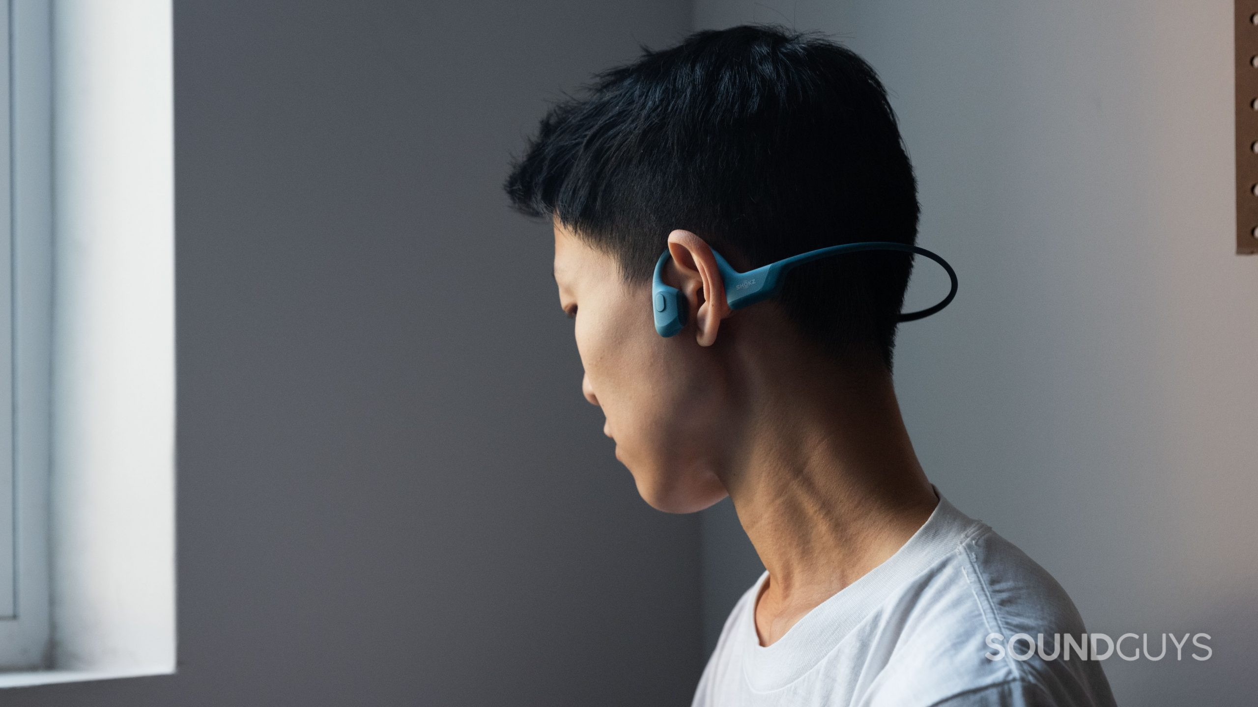 A person wears the Shokz OpenRun Pro bone conduction headphones.