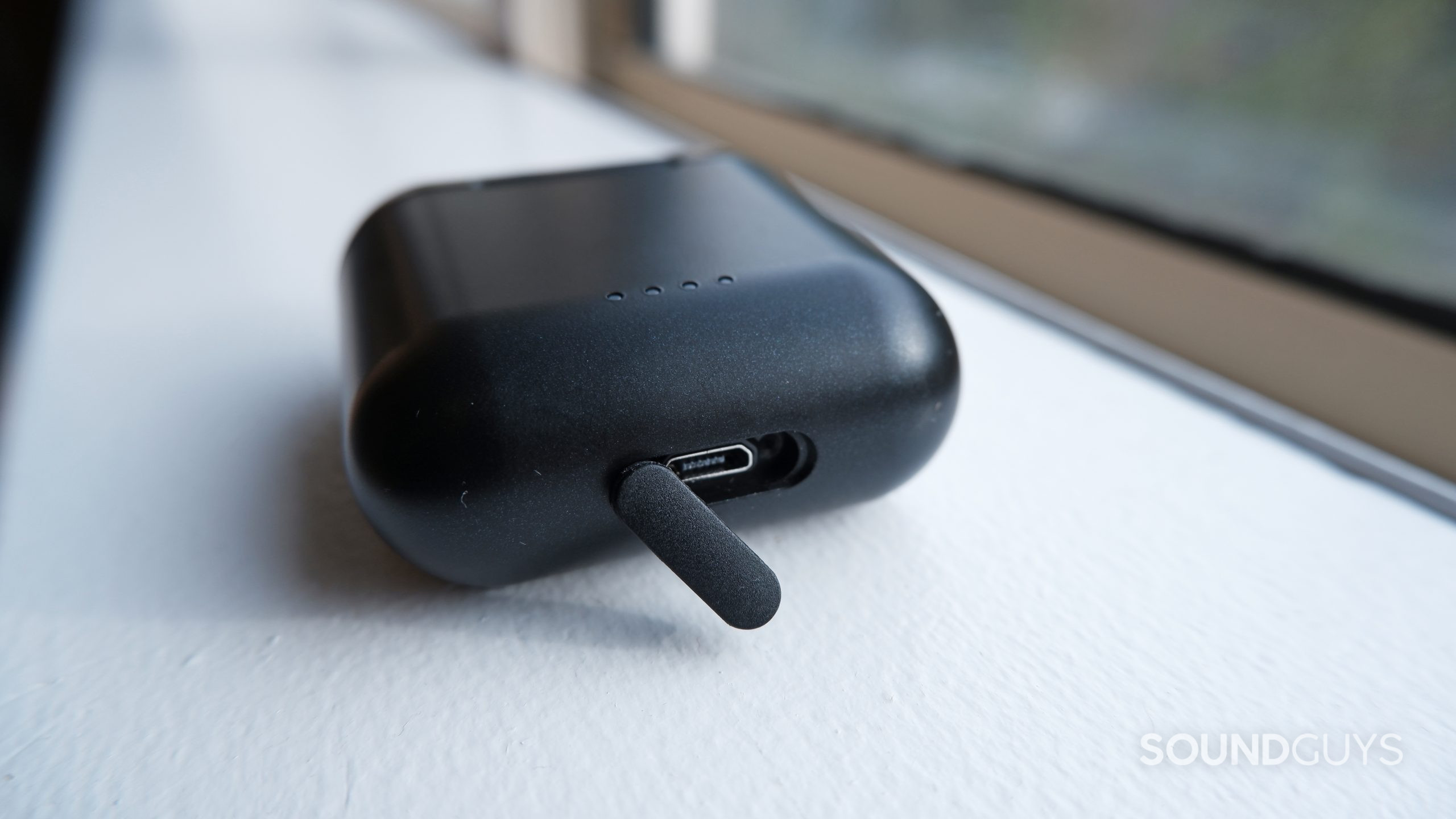 The TOZO T6 case sits on a window sill showing the USB-C port cover open.