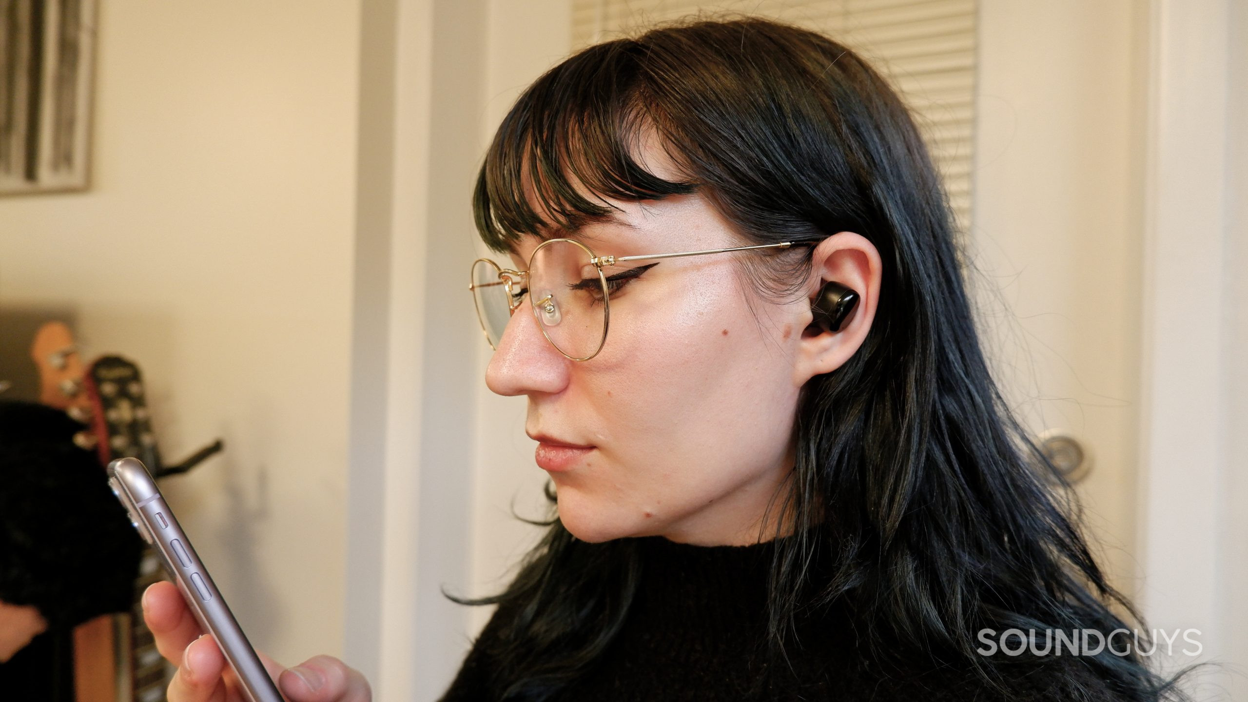 The TOZO T6 earbuds in a person's ears looking at a phone.