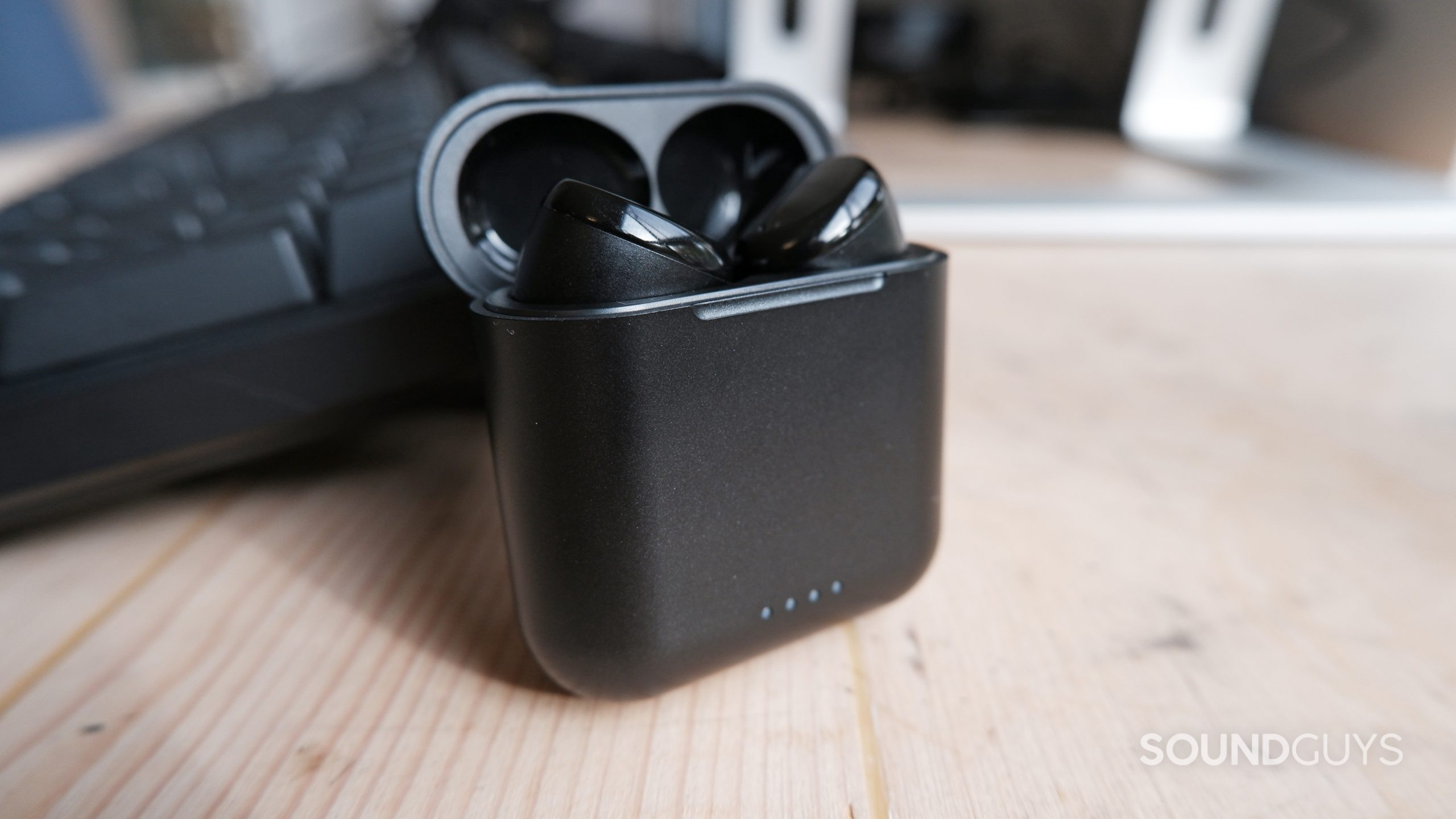 The TOZO T6 case open on a desk with the earbuds inside the case.