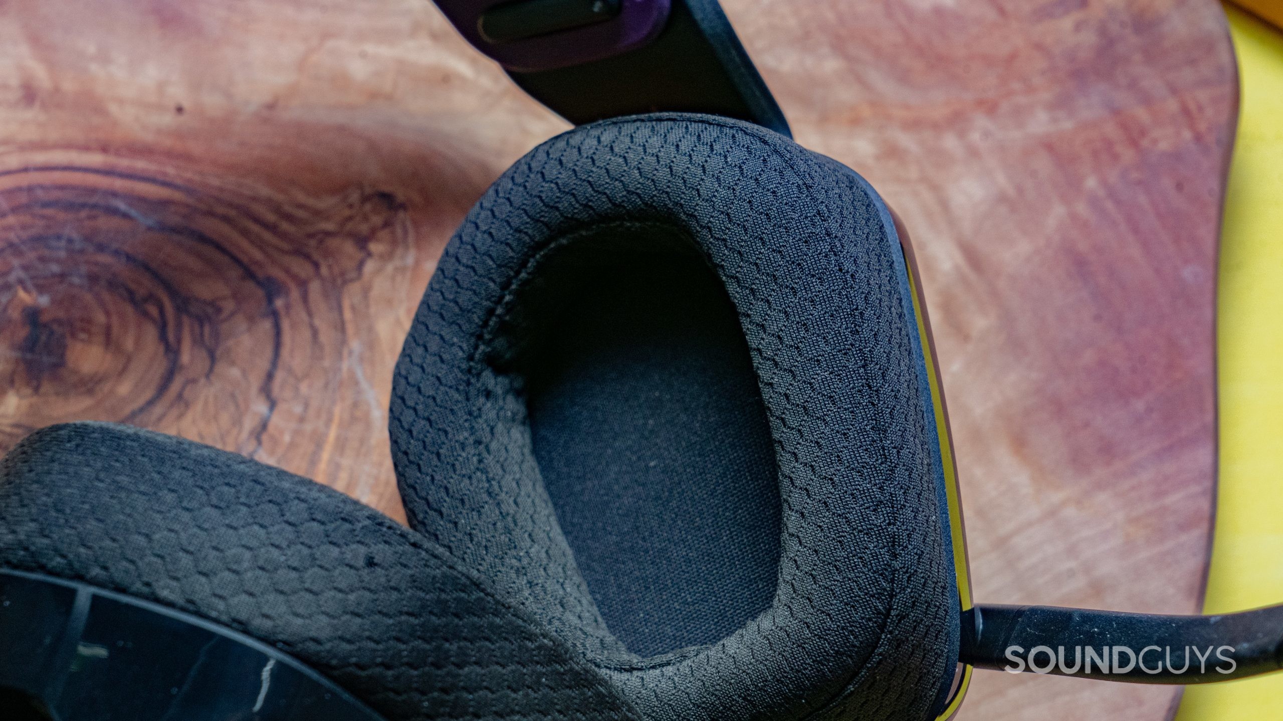 The Logitech G335 ear cup interior on top of a wooden surface.