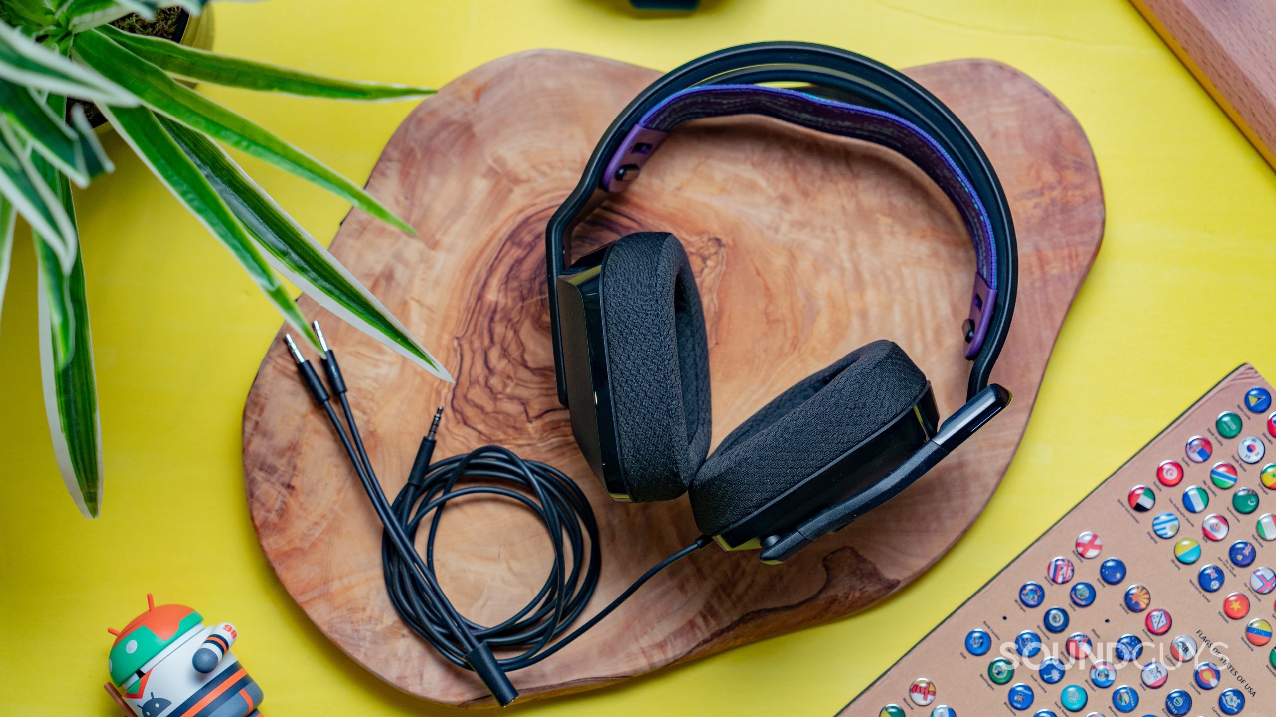 The Logitech G335, long view, on top of a wooden table with the cable curled around.