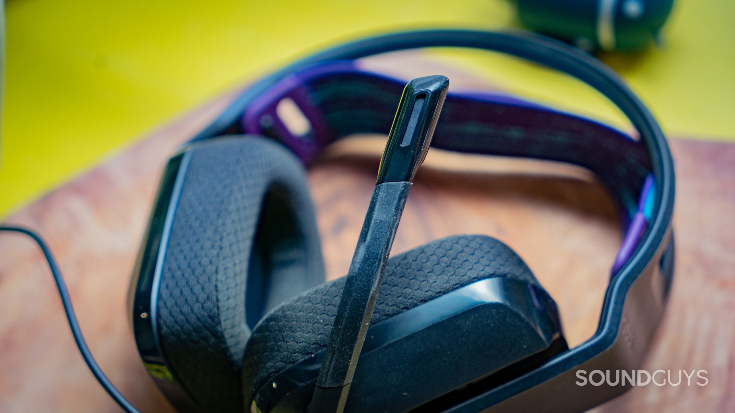 The Logitech G335 sitting on a wooden table with a green background.