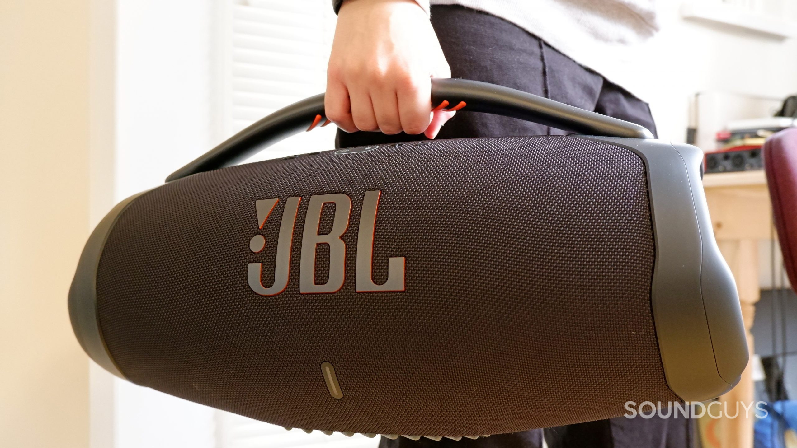 The JBL Boombox 3 being carried by the handle.