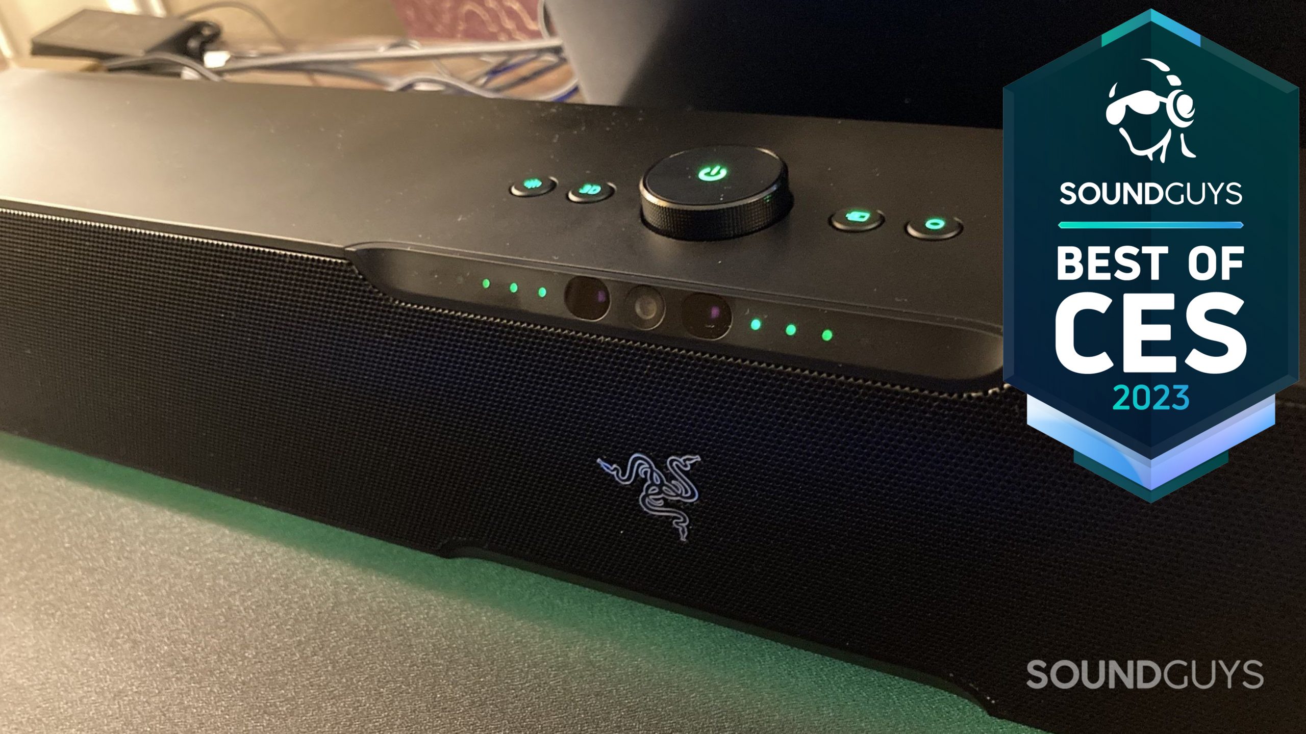 The Razer Leviathan V2 Pro soundbar sits on a table with its controls illuminted.