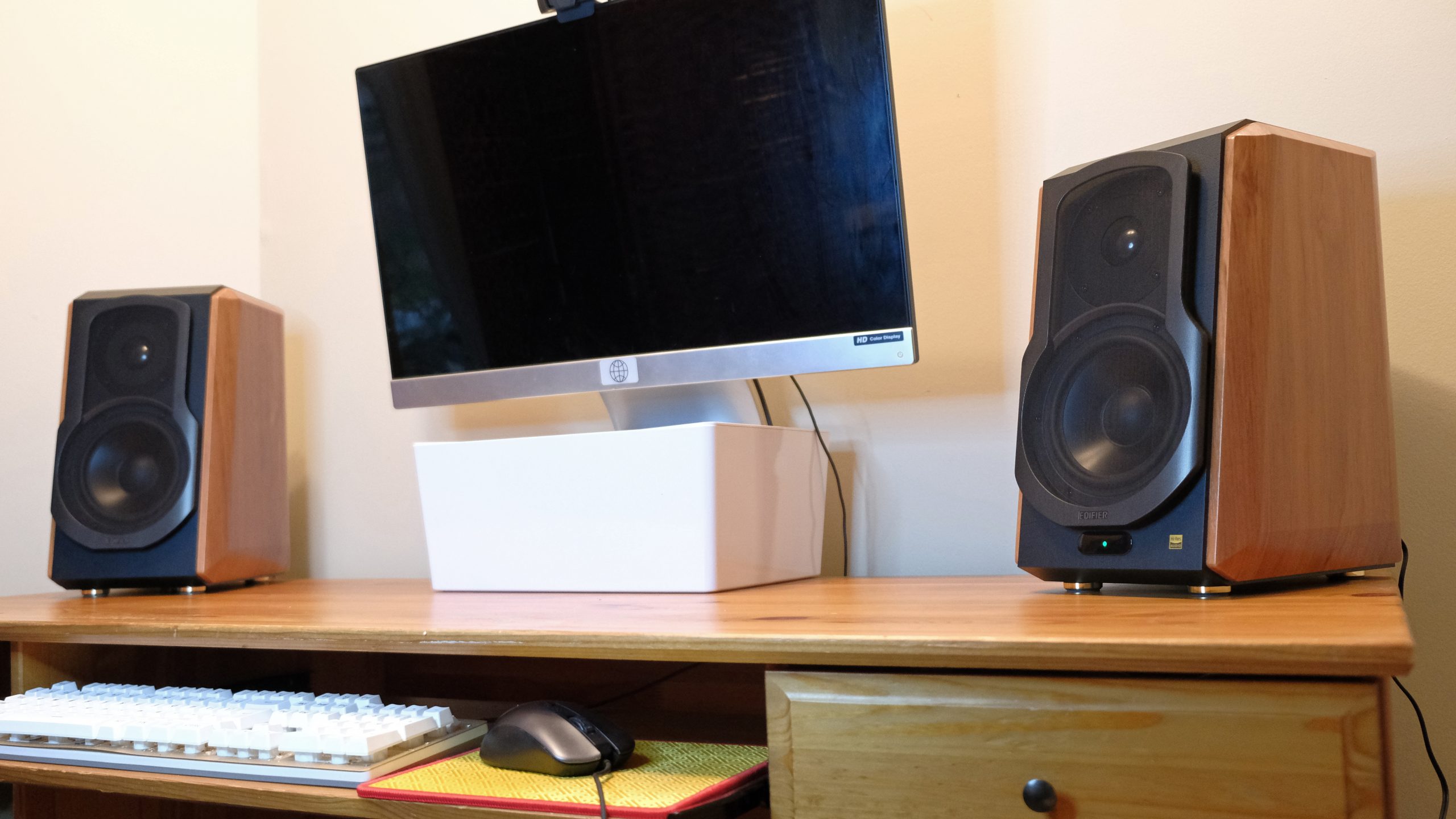 The Edifier S1000W speakers sit on a wood desk with a computer monitor in the middle.