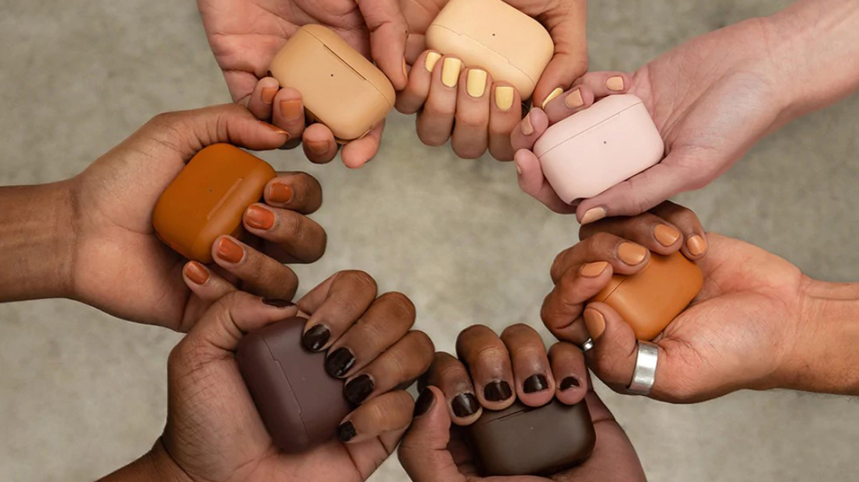 A top down shot shows seven hands holding the color matched cases of the JLab GO Air TONES.