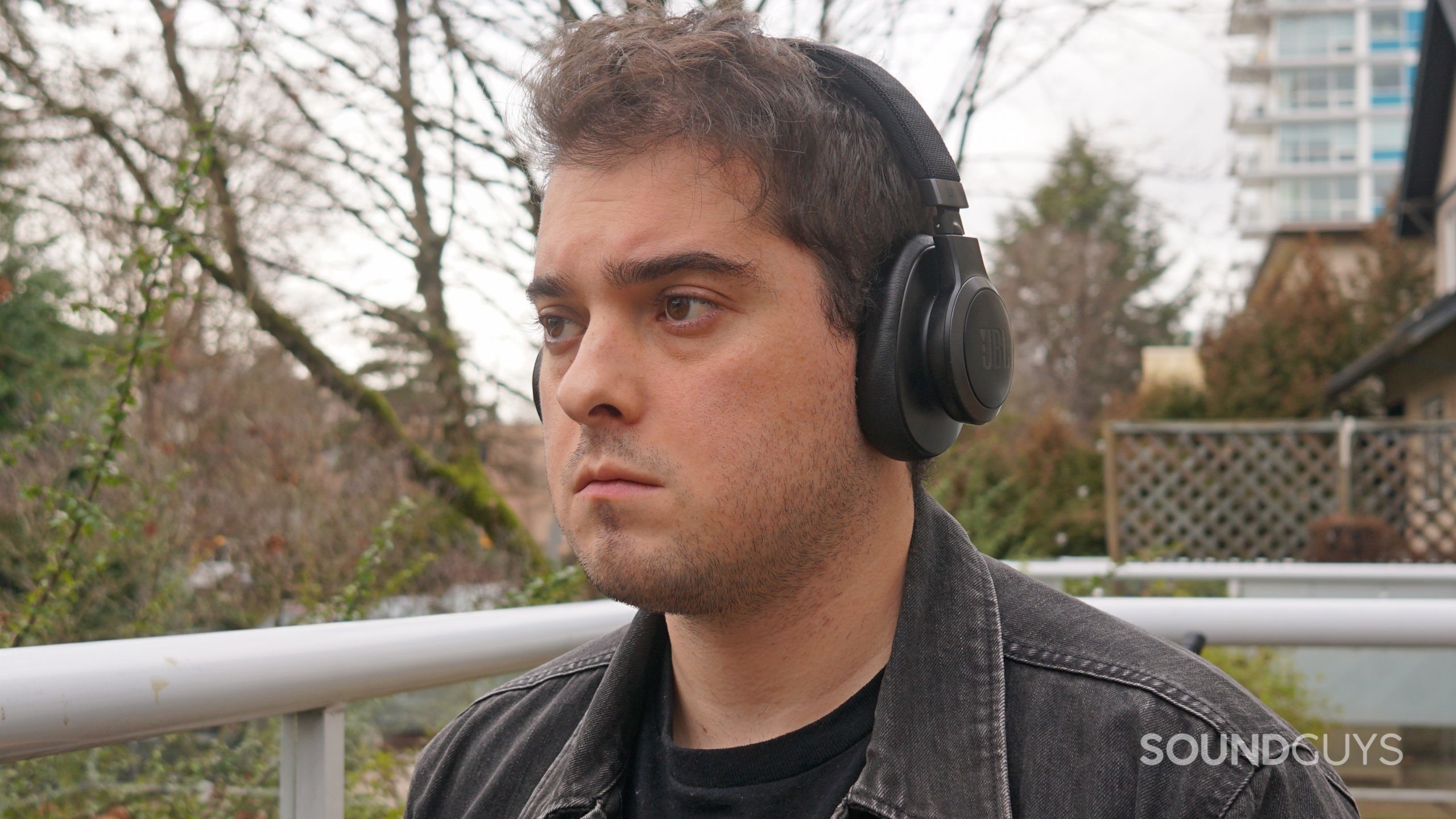 A man wears the JBL Live 600NC outside.