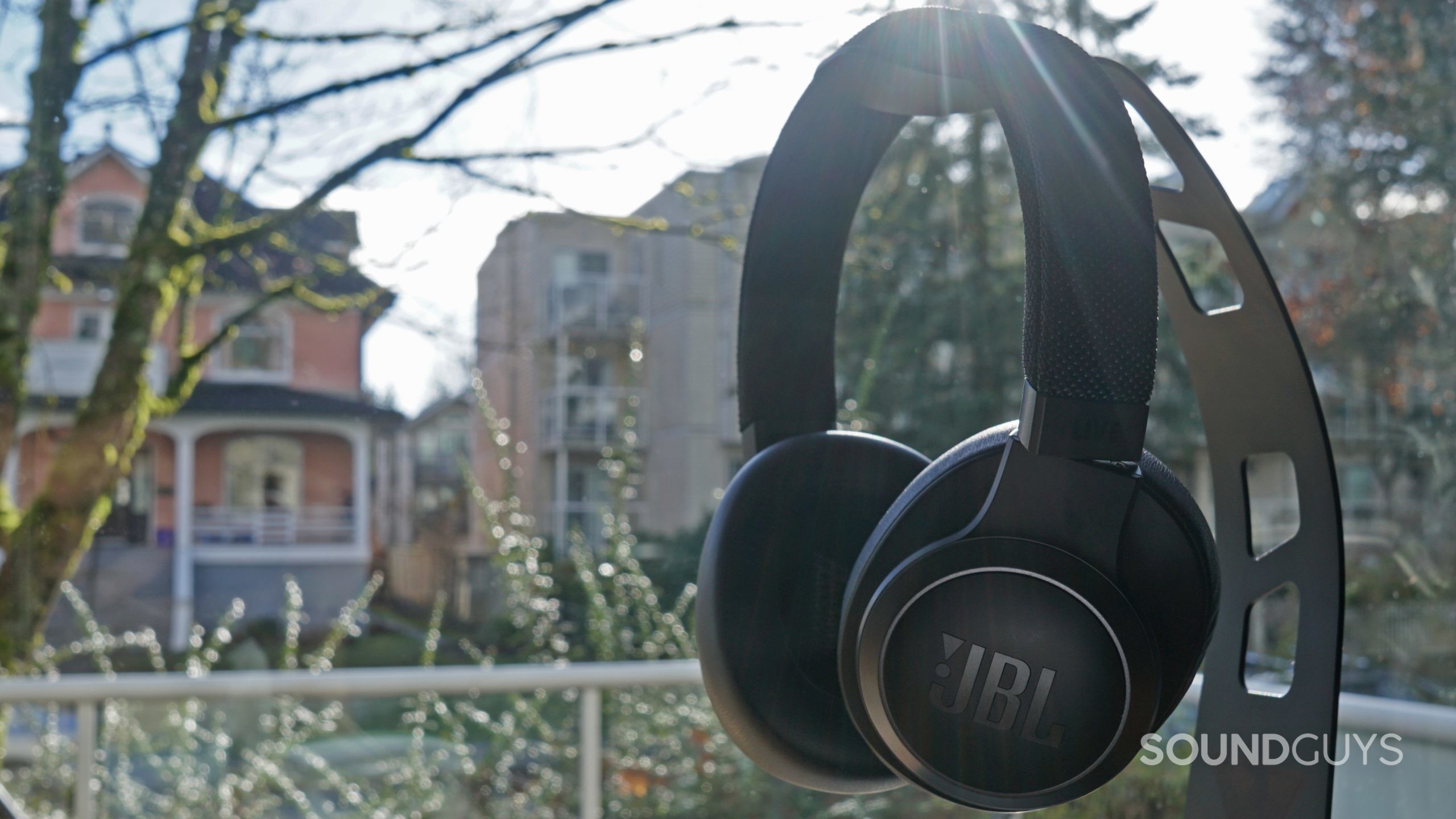 The JBL Live 660NC sits on a headphone stand.