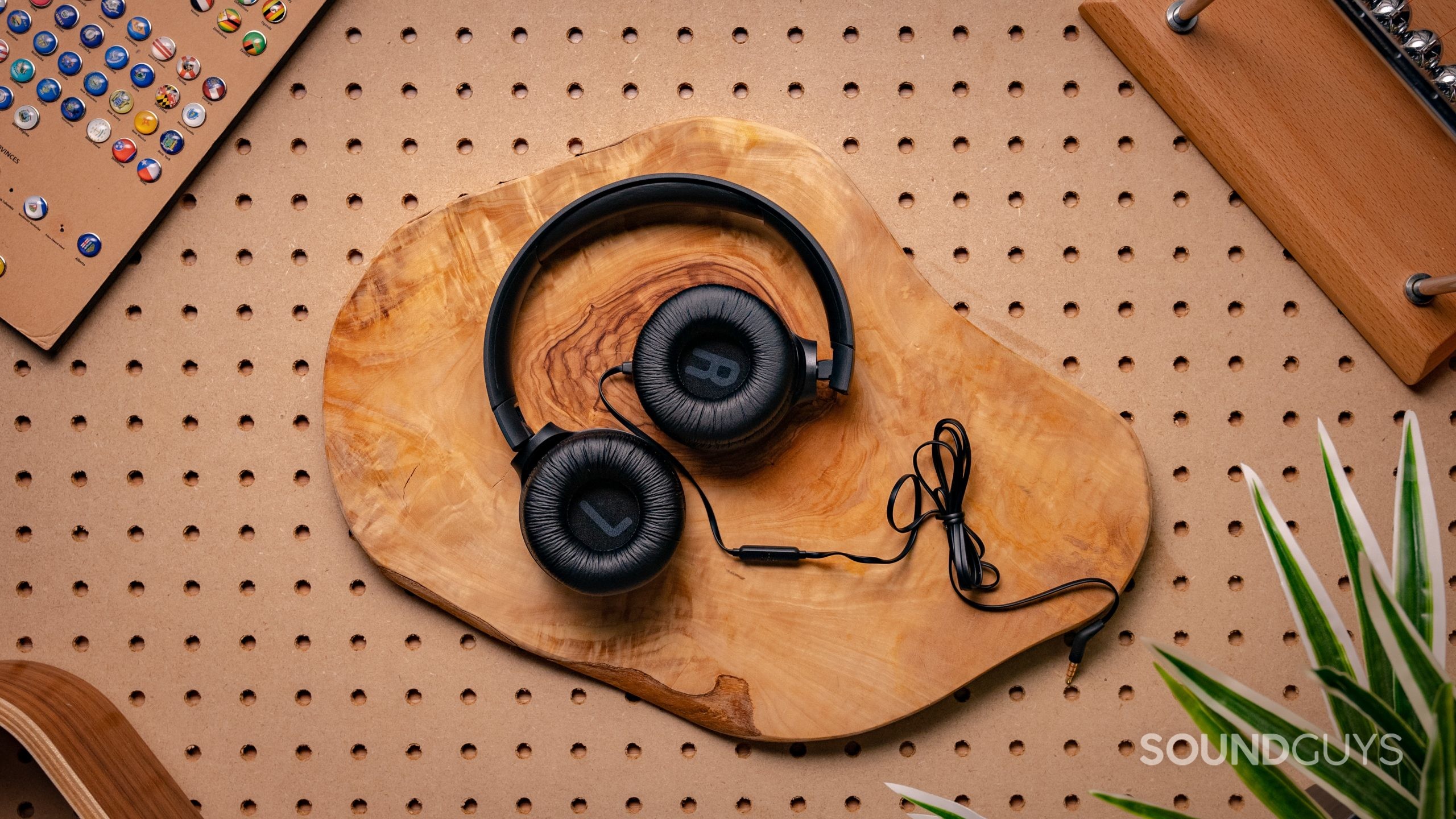JBL Tune 500 Featured Image #2 The JBL Tune 500 sitting on a wooden table in a semi-folded position, showing the ear cup interiors.