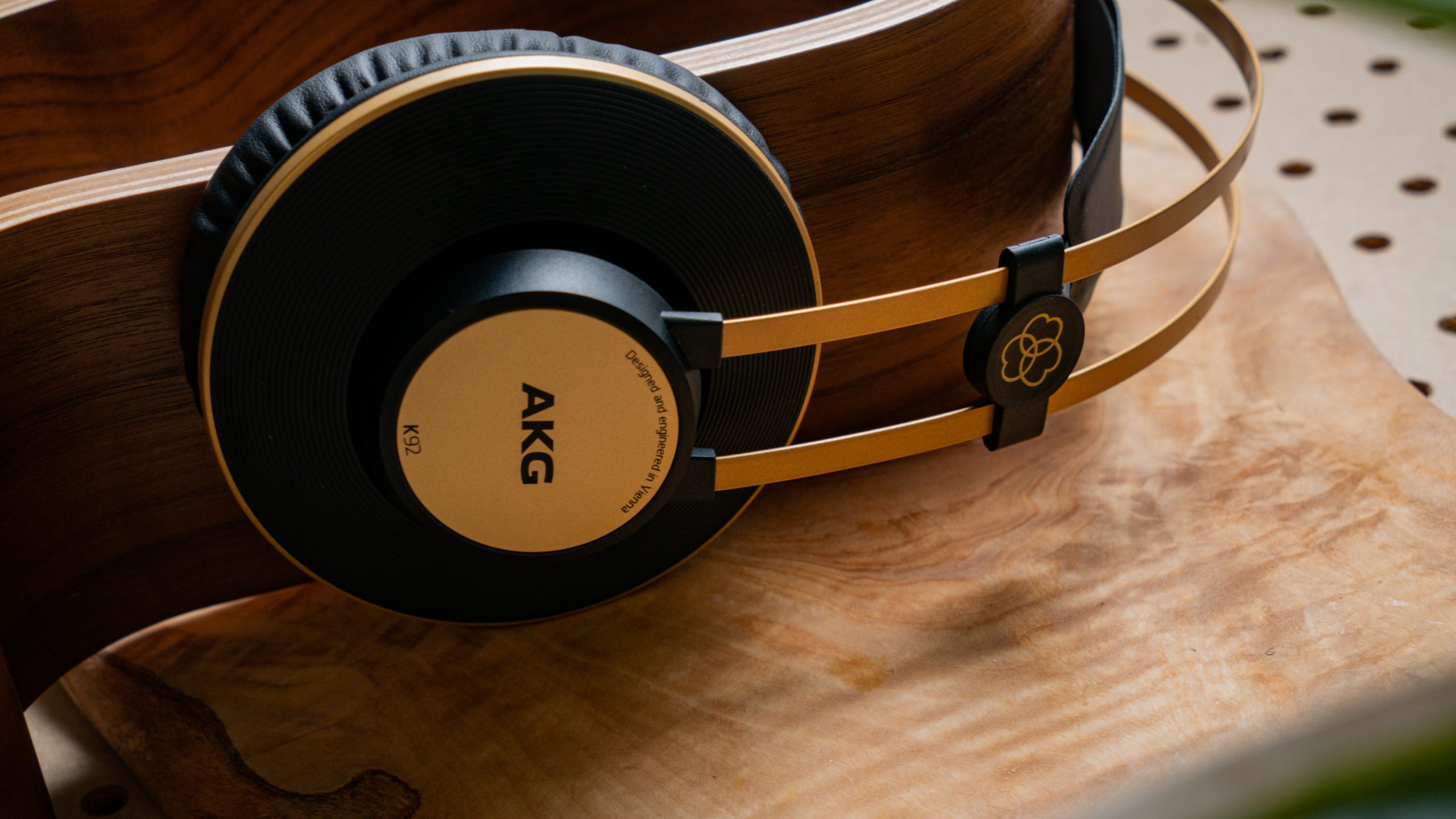 A photo of the AKG K92 lying on a wooden slab, atop pegboard.