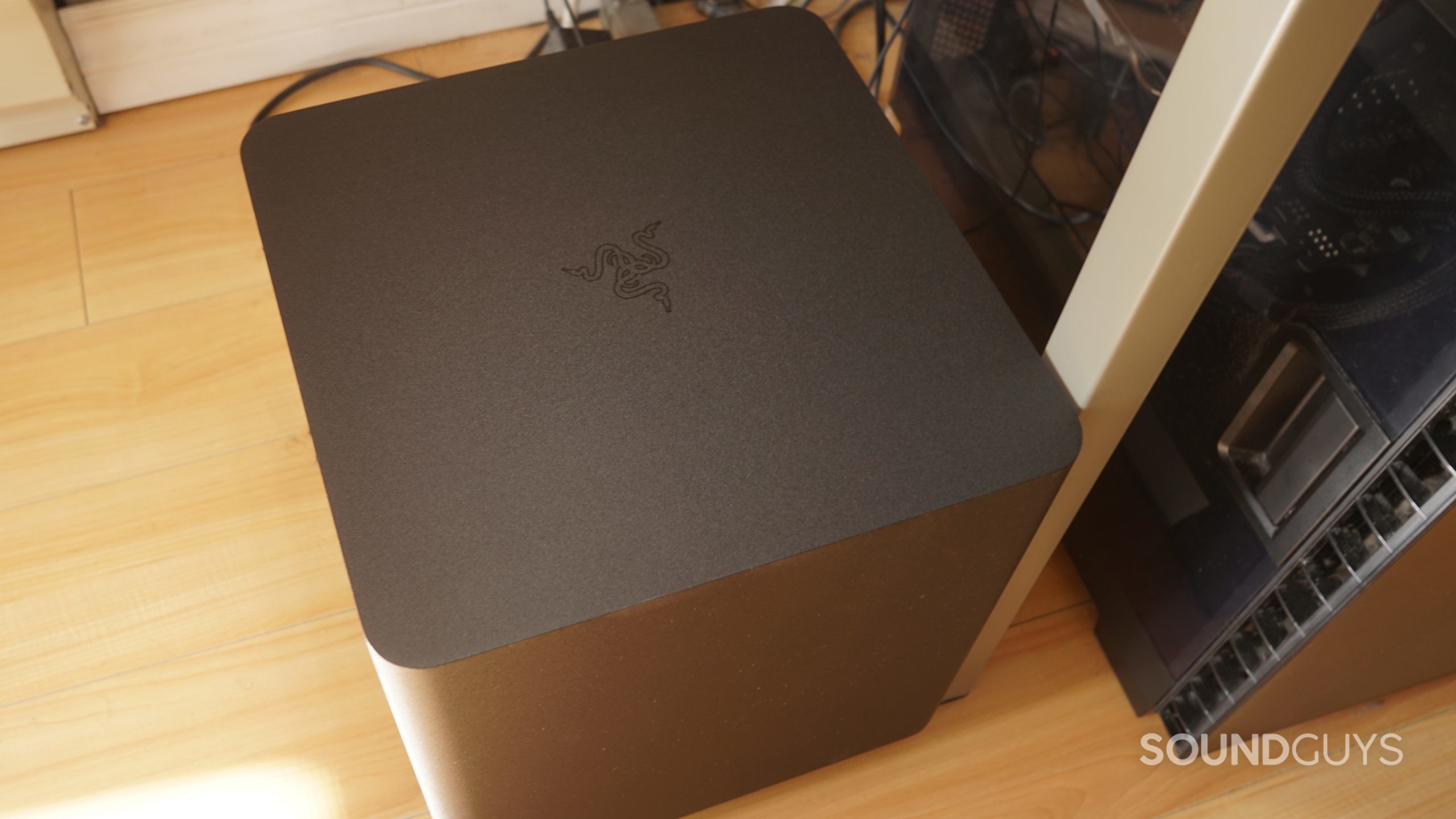 The Razer Leviathan V2 Pro woofer is plugged in under a desk, next to a Windows PC tower.