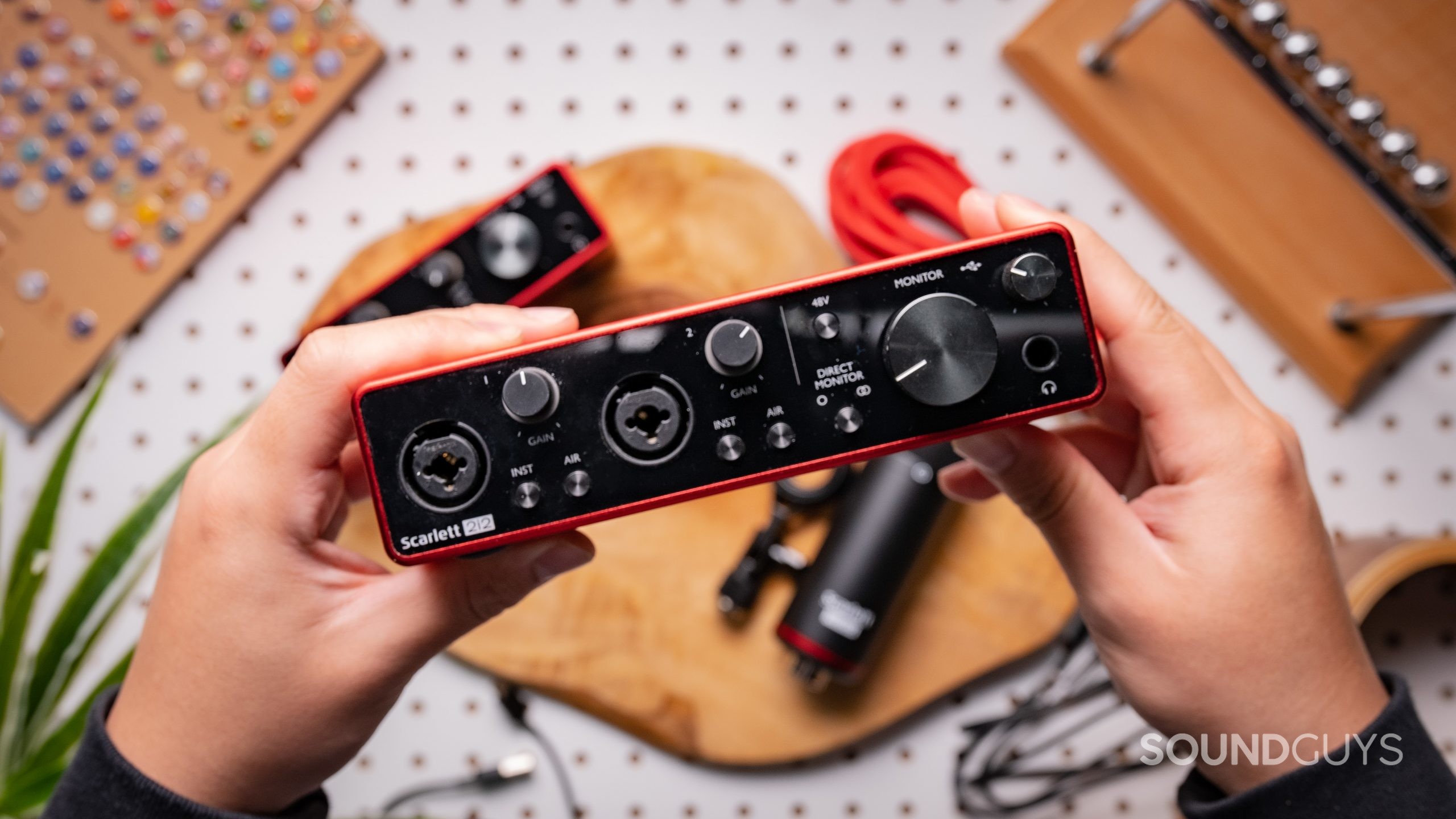 The Focusrite Scarlett 2i2 is held above a Focusrite Scarlett Solo.