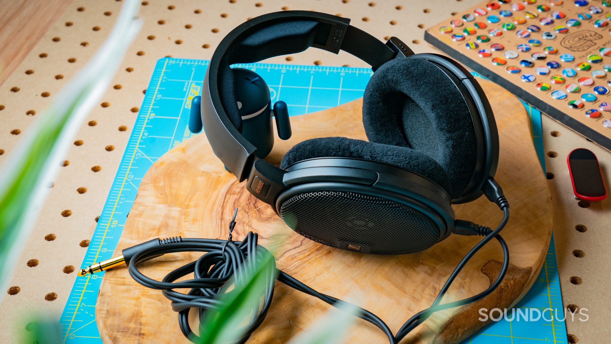 A photo of the Sennheiser HD 660S2 sitting atop a slab of wood, with cable bundled up.