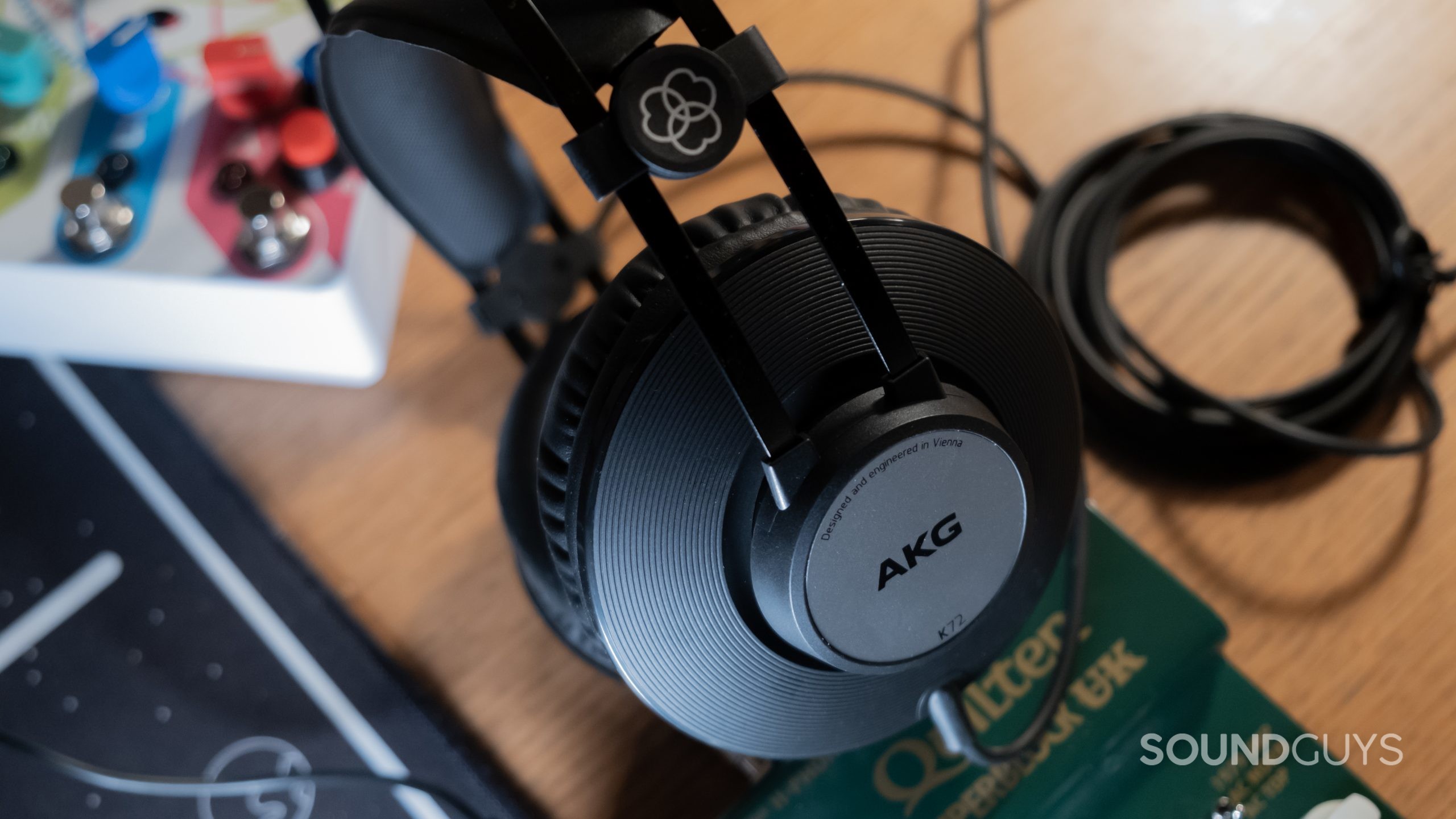 A close up of the ear cup of the AKG K72 with music gear in the background.