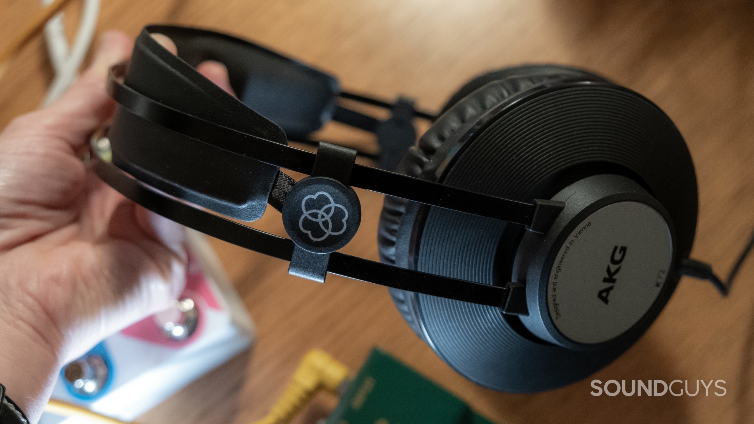 A hand tugs at the AKG K72 tension headband.